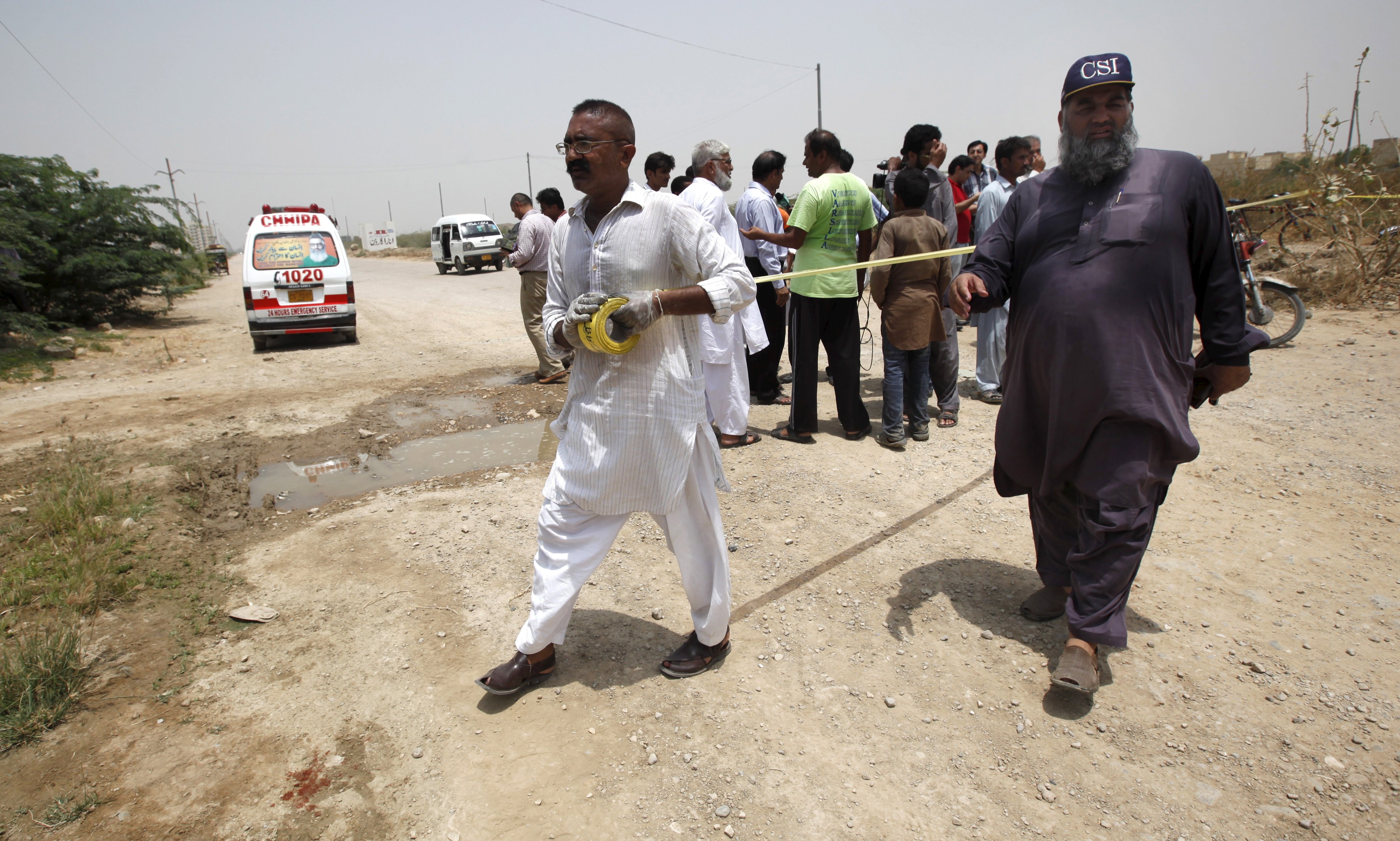 Security officials cordon off the area at the scene of an attack on a bus in Karachi