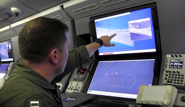 Still image from United States Navy video shows a U.S. Navy crewman aboard a surveillance aircraft viewing a computer screen purportedly showing Chinese construction on the reclaimed land of Fiery Cross Reef in the disputed Spratly Islands