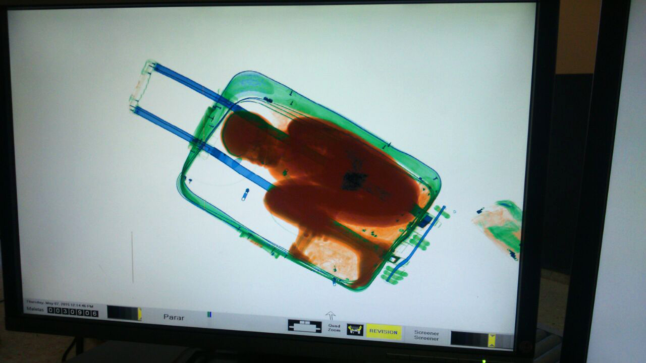 In this photo released by the Spanish Guardia Civil on Friday, May 8, 2015, a boy curled up inside a suitcase is seen on the display of a scanner at the border crossing in Ceuta, a Spanish city enclave in North Africa.