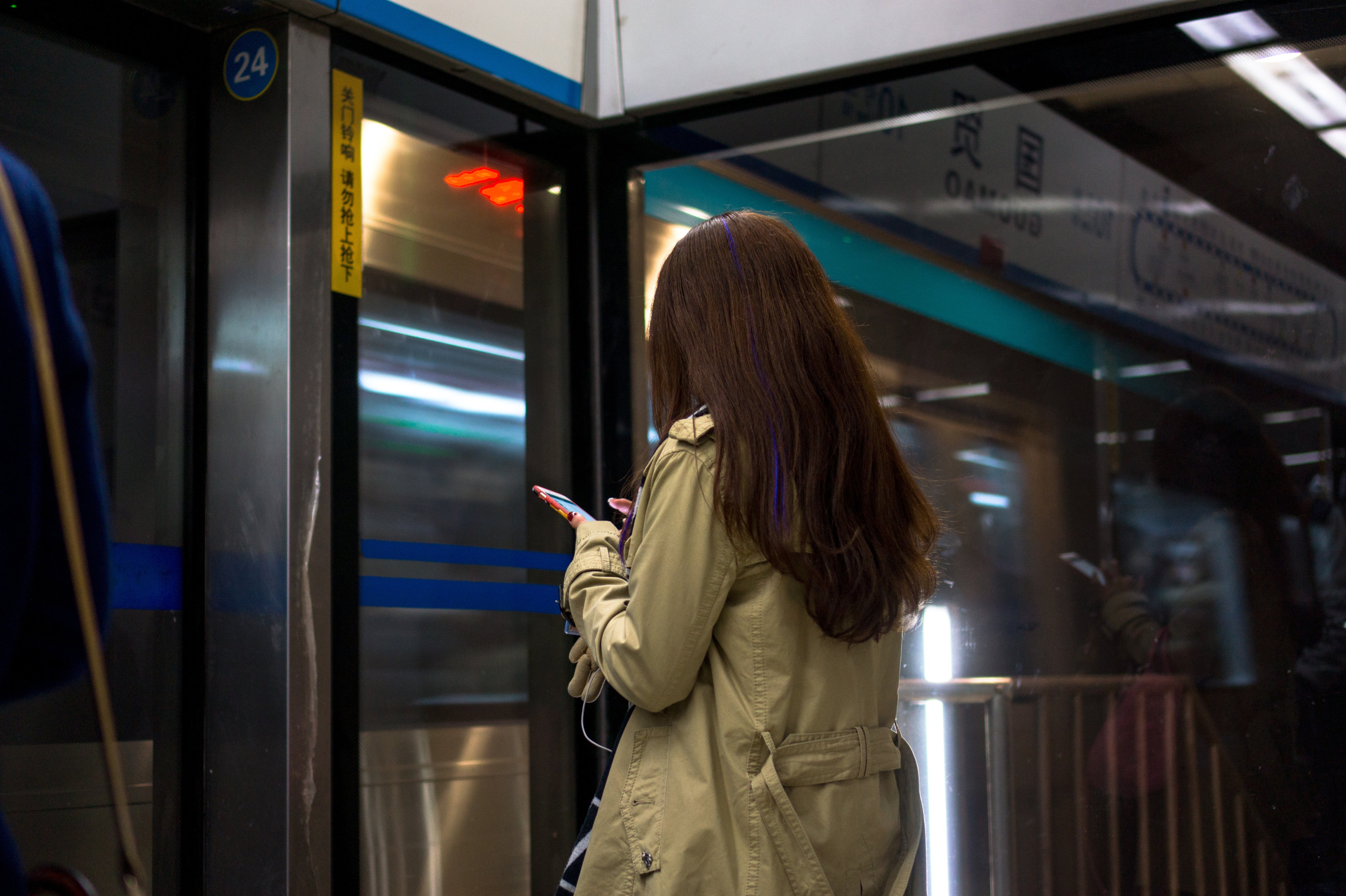 Passengers read their smart phones in Beijing on March 8, 2015.