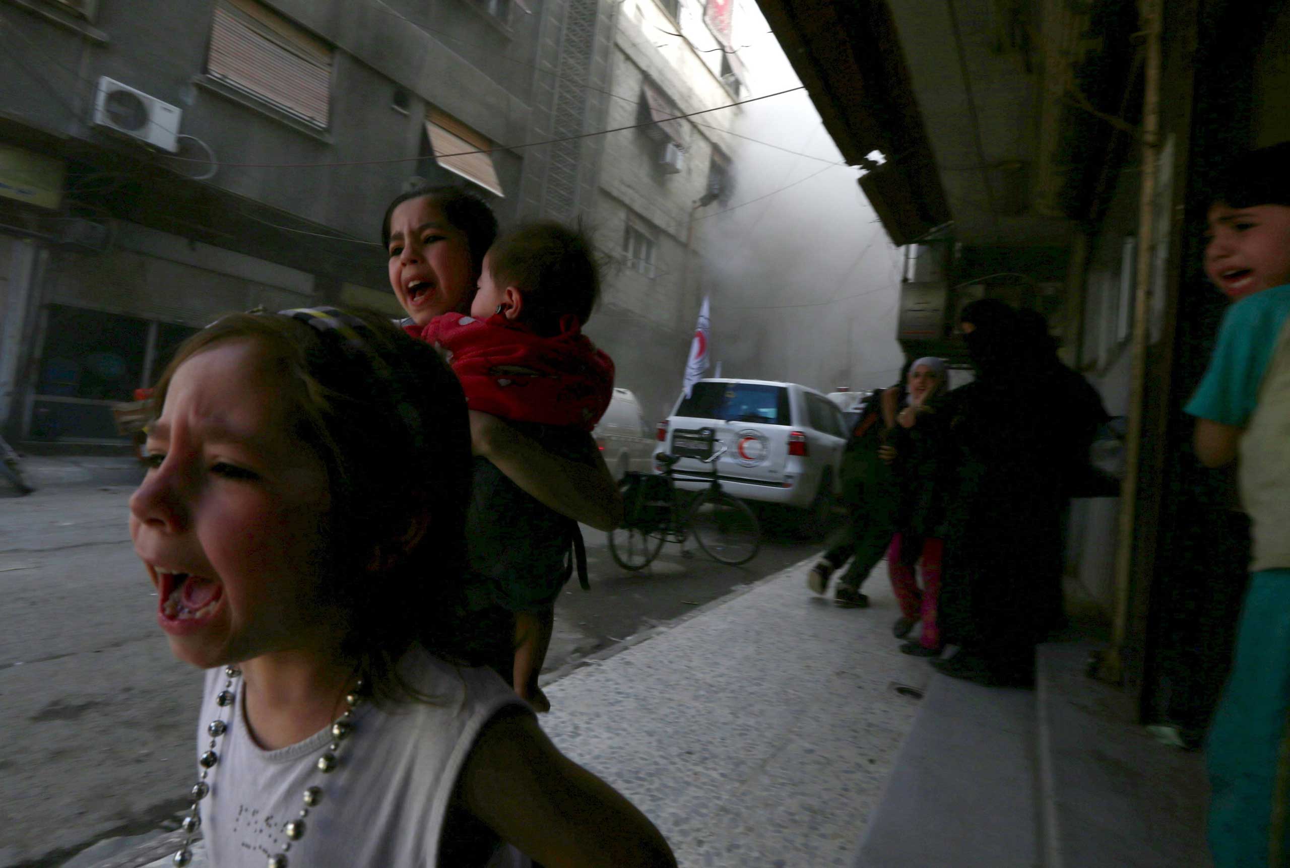 Children react after what activists said was shelling by forces loyal to Syria's President Bashar al-Assad near the Syrian Arab Red Crescent center in the Douma neighborhood of Damascus on May 6, 2015. (Bassam Khabieh—Reuters)