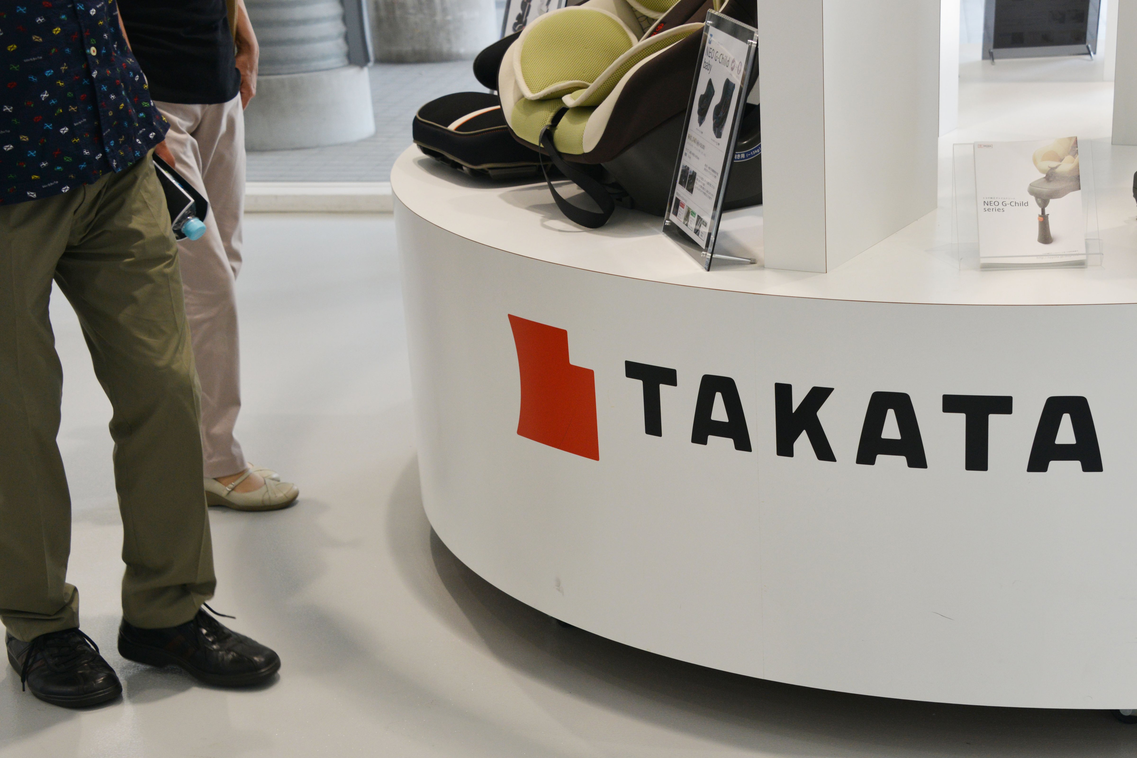 A visitor walks past displays of Takata Corp at a showroom for vehicles in Tokyo, Japan on May 20, 2015.