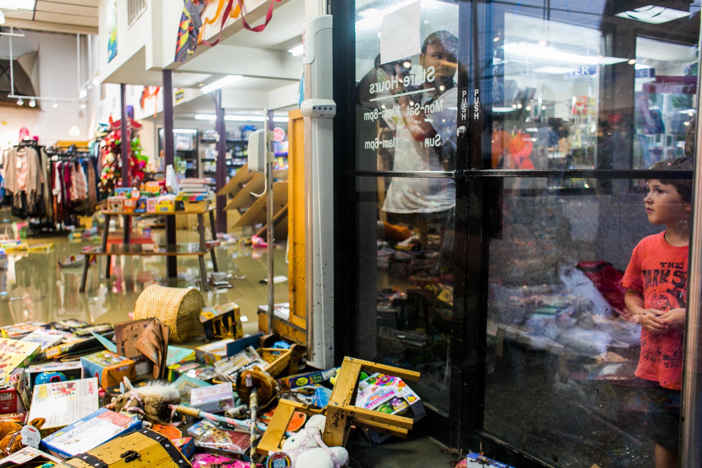 Lucas Rivas looks into the flooded Whole Earth Provisions Company after days of heavy rain in Austin on May 25, 2015.