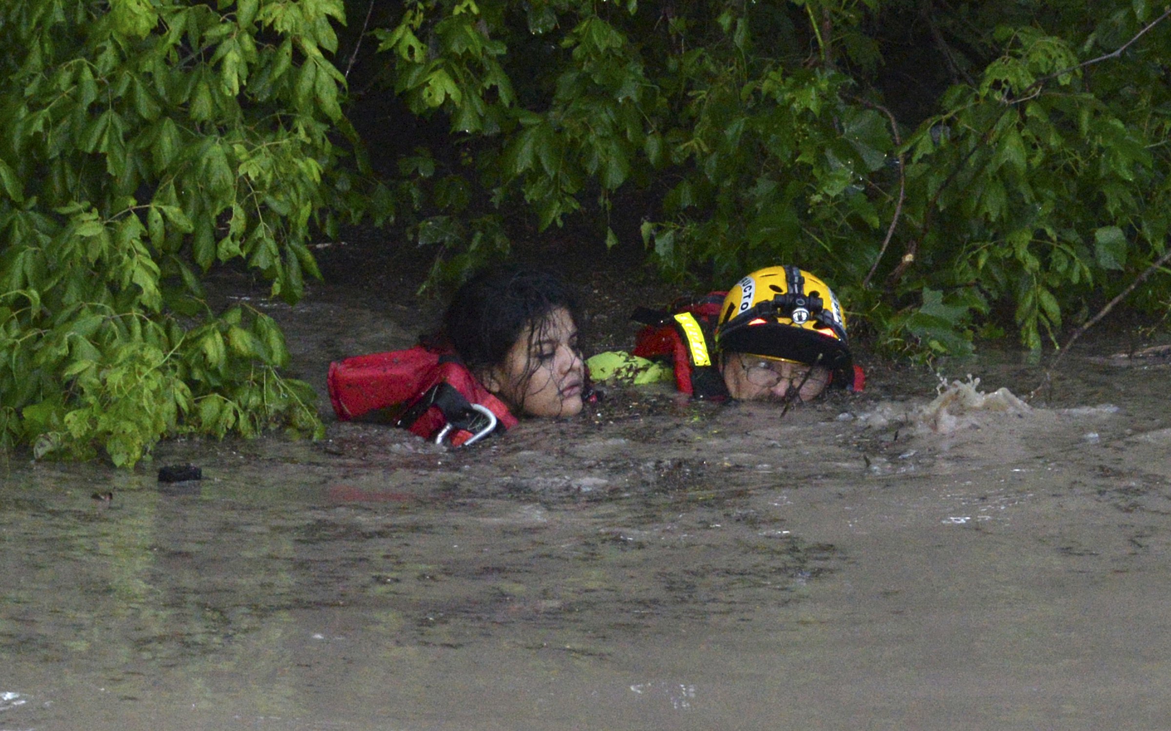 San Marcos Firefighter Jay Horton rescues a woman from the flood waters in San Marcos, Texas on May 24, 2015.