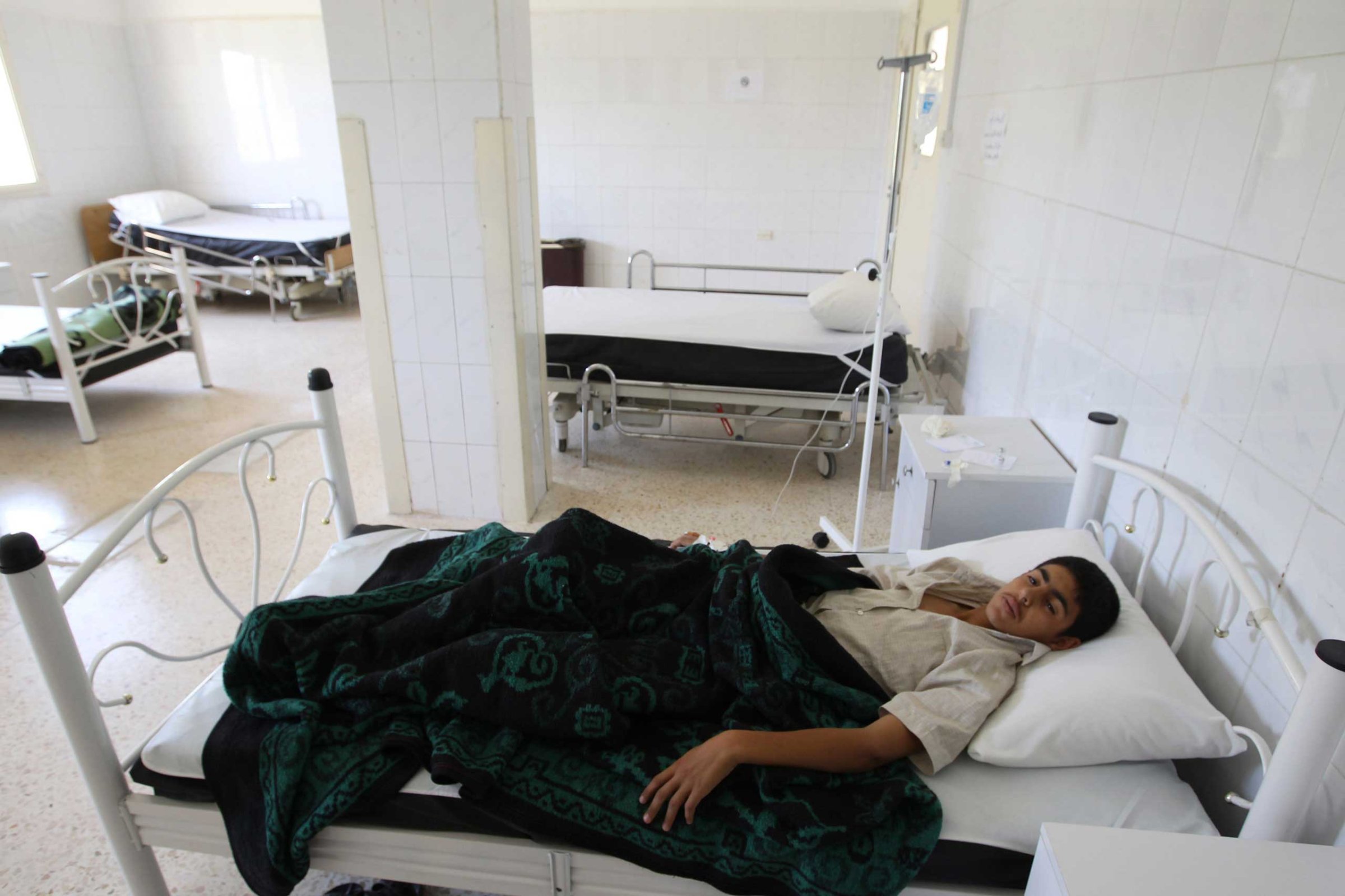 A boy infected by typhoid from polluted water, lies at a hospital in al-Qouniya village in Idlib, Syria, May 27, 2013.