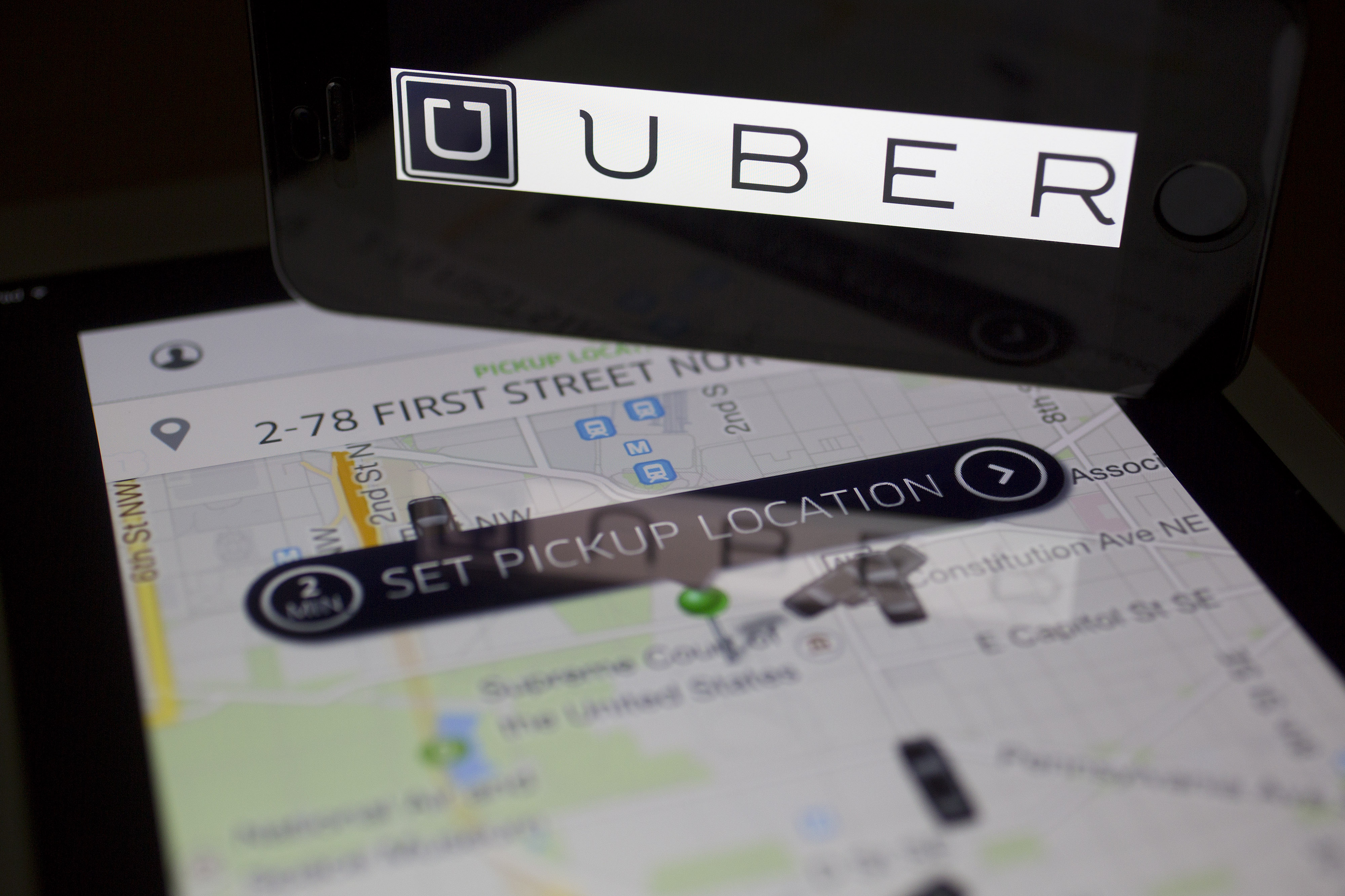 The Uber Technologies Inc. application and logo are displayed on an Apple Inc. iPhone 5s and iPad Air in this arranged photograph in Washington, D.C., U.S., on Wednesday, March 5, 2014.