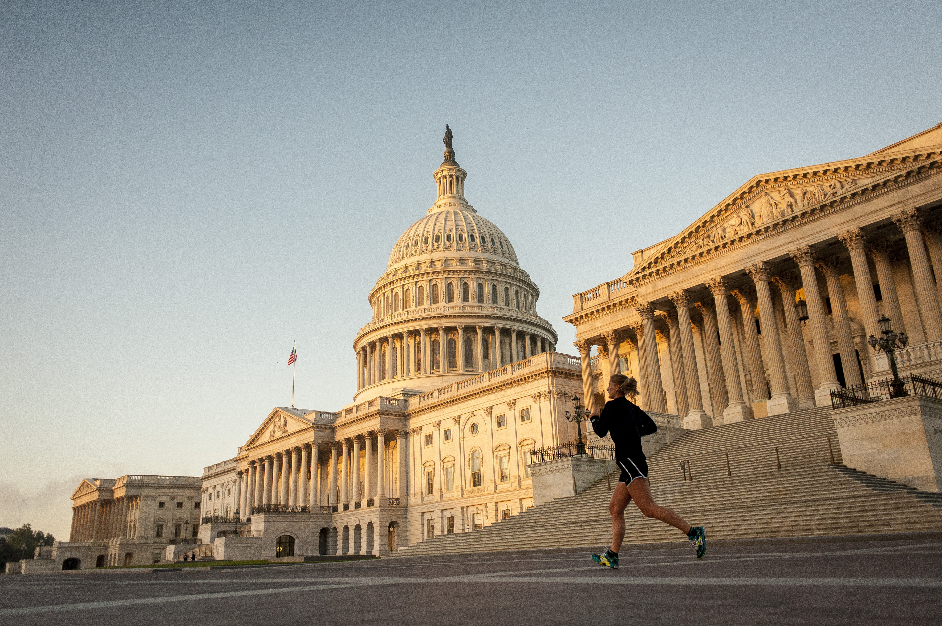 A jogger runs past the United States Capitol building at sunrise in Washington, D.C., U.S., on Tuesday, Oct. 15, 2013. (Pete Marovich—Bloomberg/Getty Images)