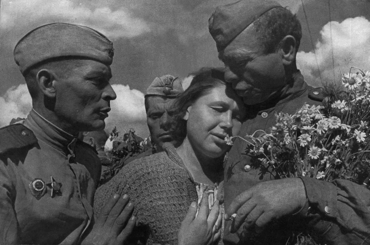 A woman celebrating the defeat of Nazi Germany with members of the victorious Soviet Red Army in 1945. Found in the collection of the Moscow Photo Museum. (Heritage Images—Getty Images)