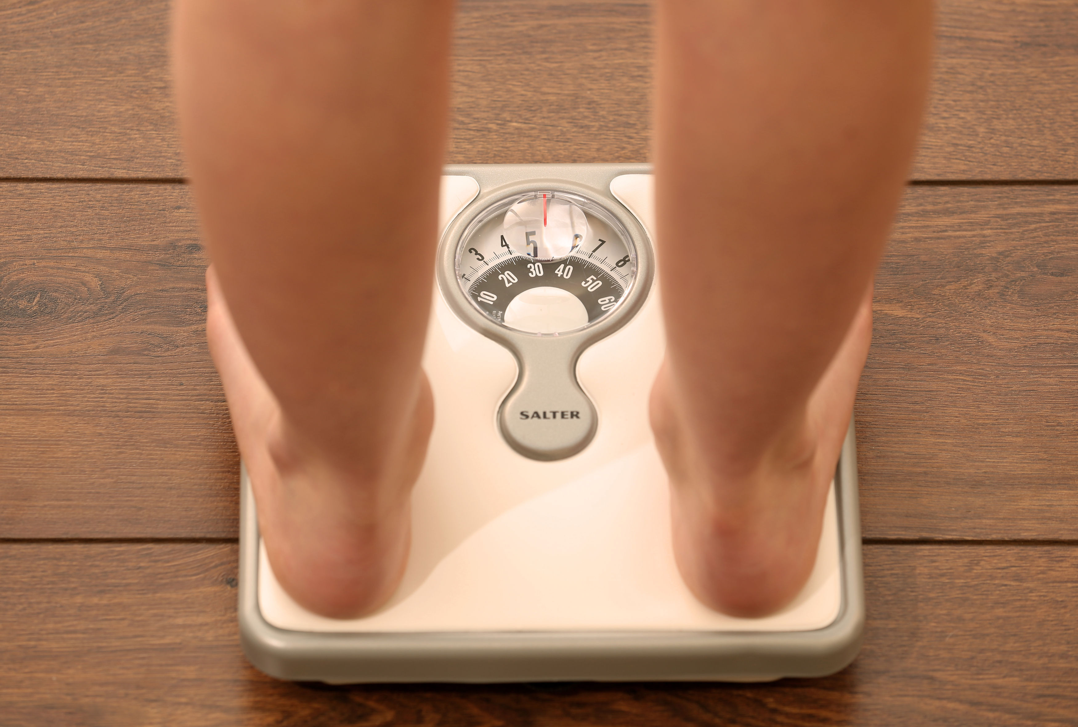 File photo dated Thursday October 16, 2014. of a young girl using a set of weighing scales as slimmers should forget what they have been told about avoiding rapid weight loss in favour of slow but sure dieting, according to new research.