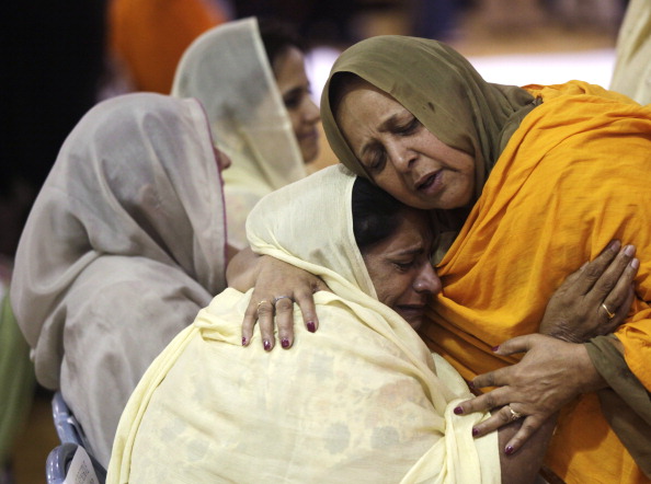 Two women hug as community members in Oak Creek, Wisc., pay respects to the six victims in the mass shooting at the Sikh Temple of Wisconsin on Aug. 10, 2012 (Darren Hauck—Getty Images)