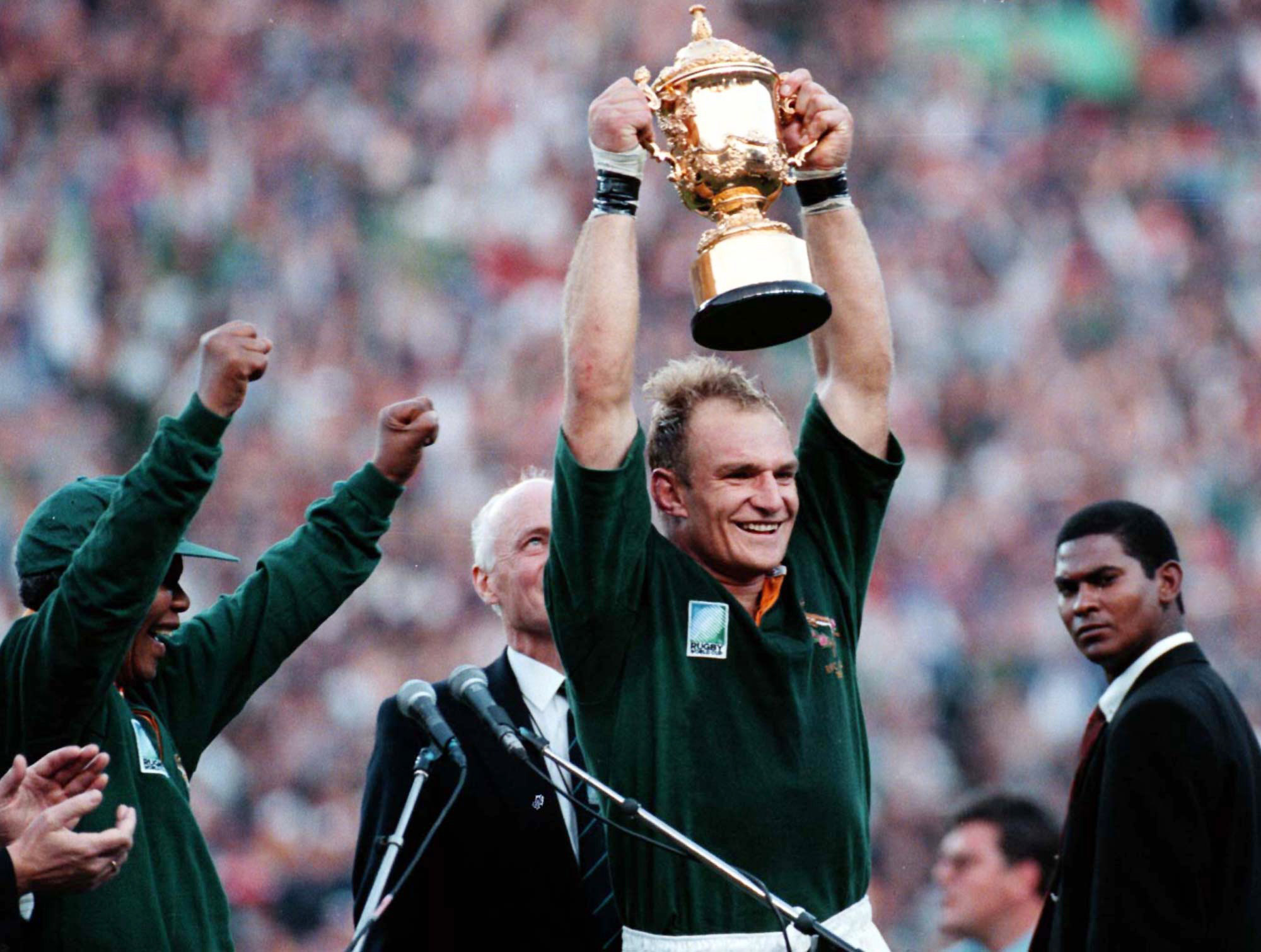 South Arican President Nelson Mandela, left, cheers as Springbok Rugby captain Francois Pienaar holds the trophy high after winning the World Cup Rugby Championship in Johannesburg on June 24 1995.