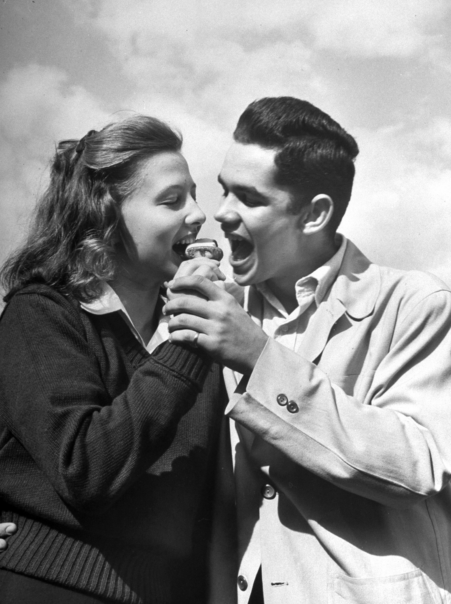 Teenagers eating an ice cream cone together, 1947.