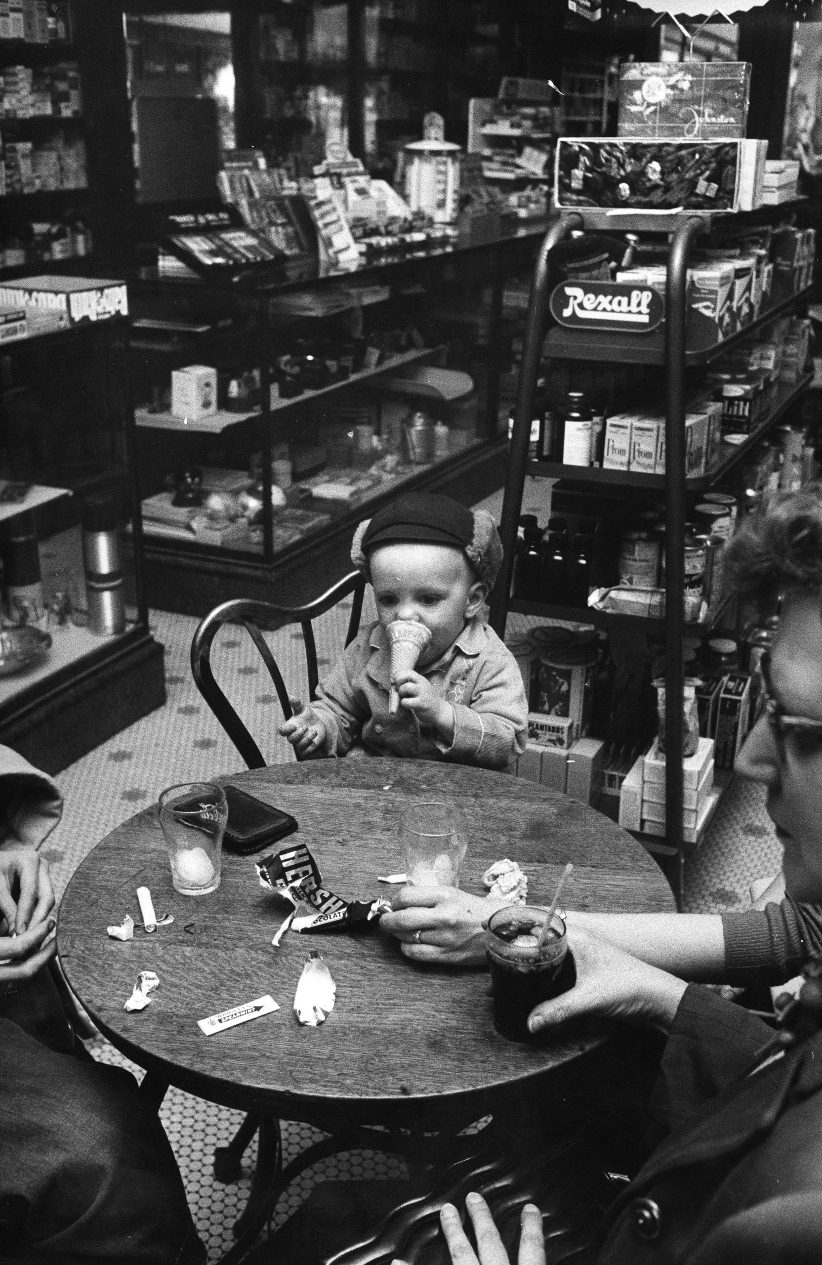 A young boy eating an ice cream cone at the local drugstore, 1957.