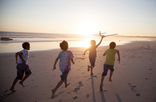 boys-running-beach-toy-plane