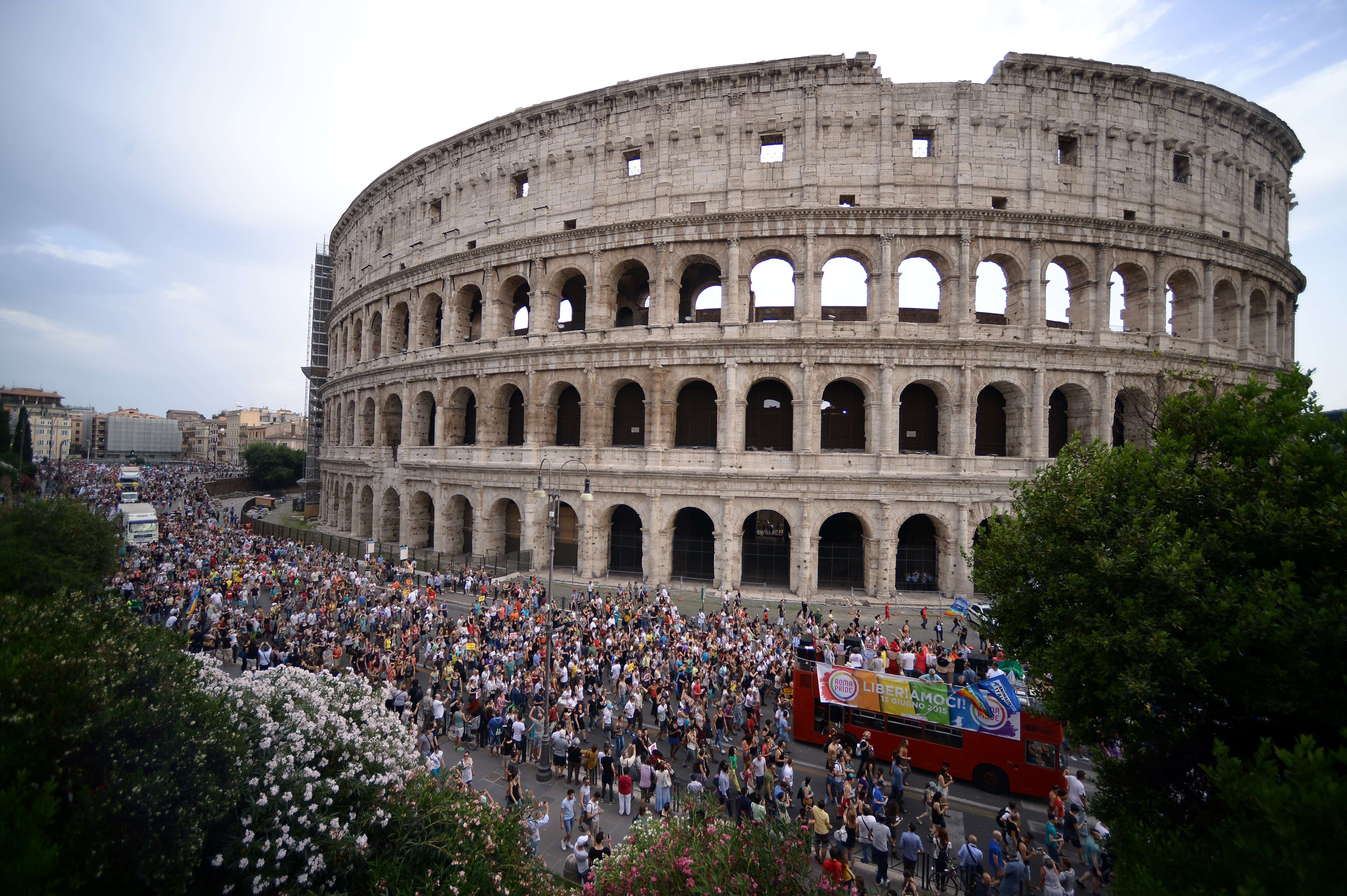 People march in front of the Colosseum during the Gay Pride Parade (LGBT) on June 13, 2015 in Rome.