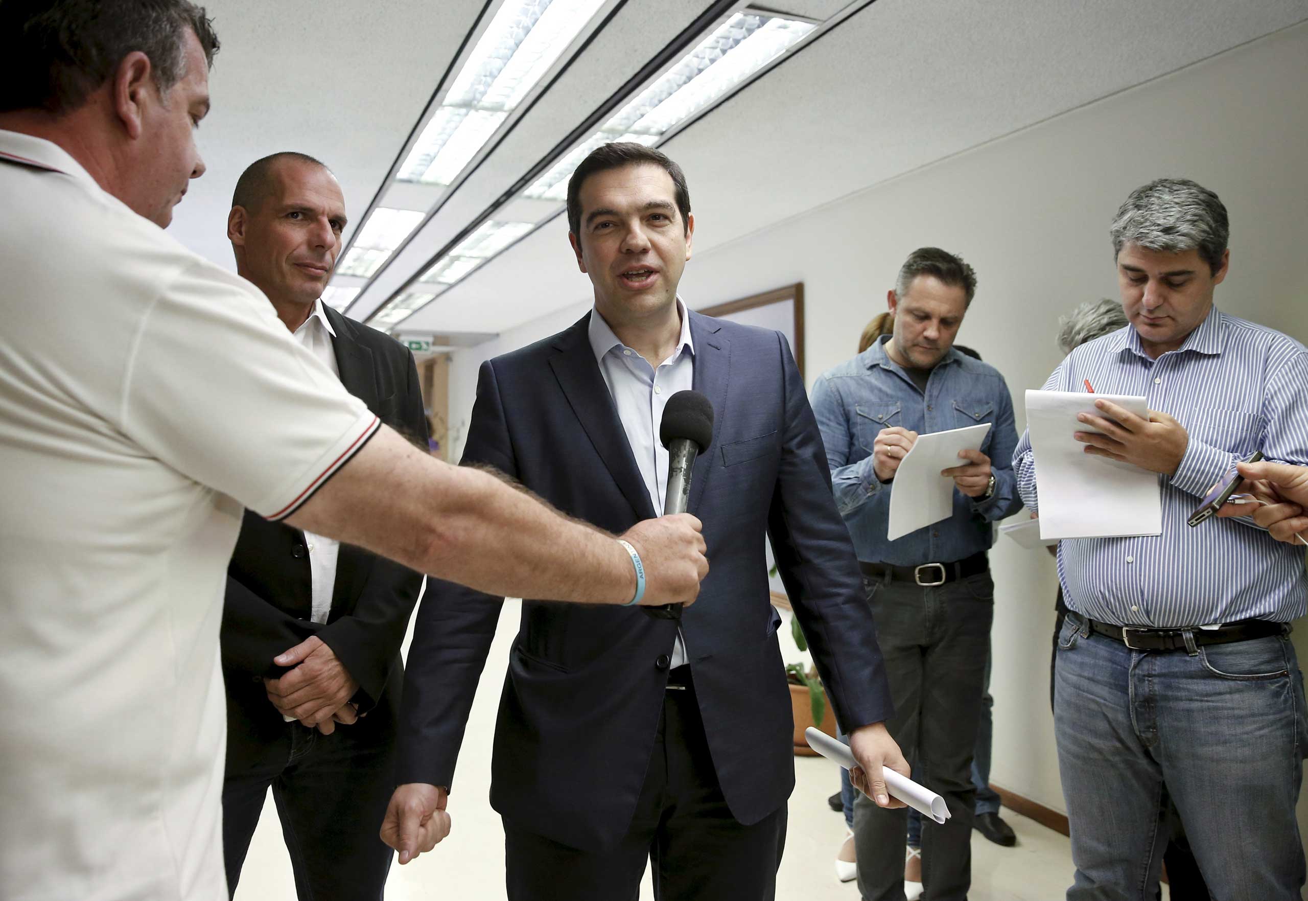 Greek Prime Minister Alexis Tsipras (C) makes statements to the media as Finance Minister Yanis Varoufakis (2nd L) looks on after a meeting at the ministry in Athens May 27, 2015. (Alkis Konstantinidis—Reuter)