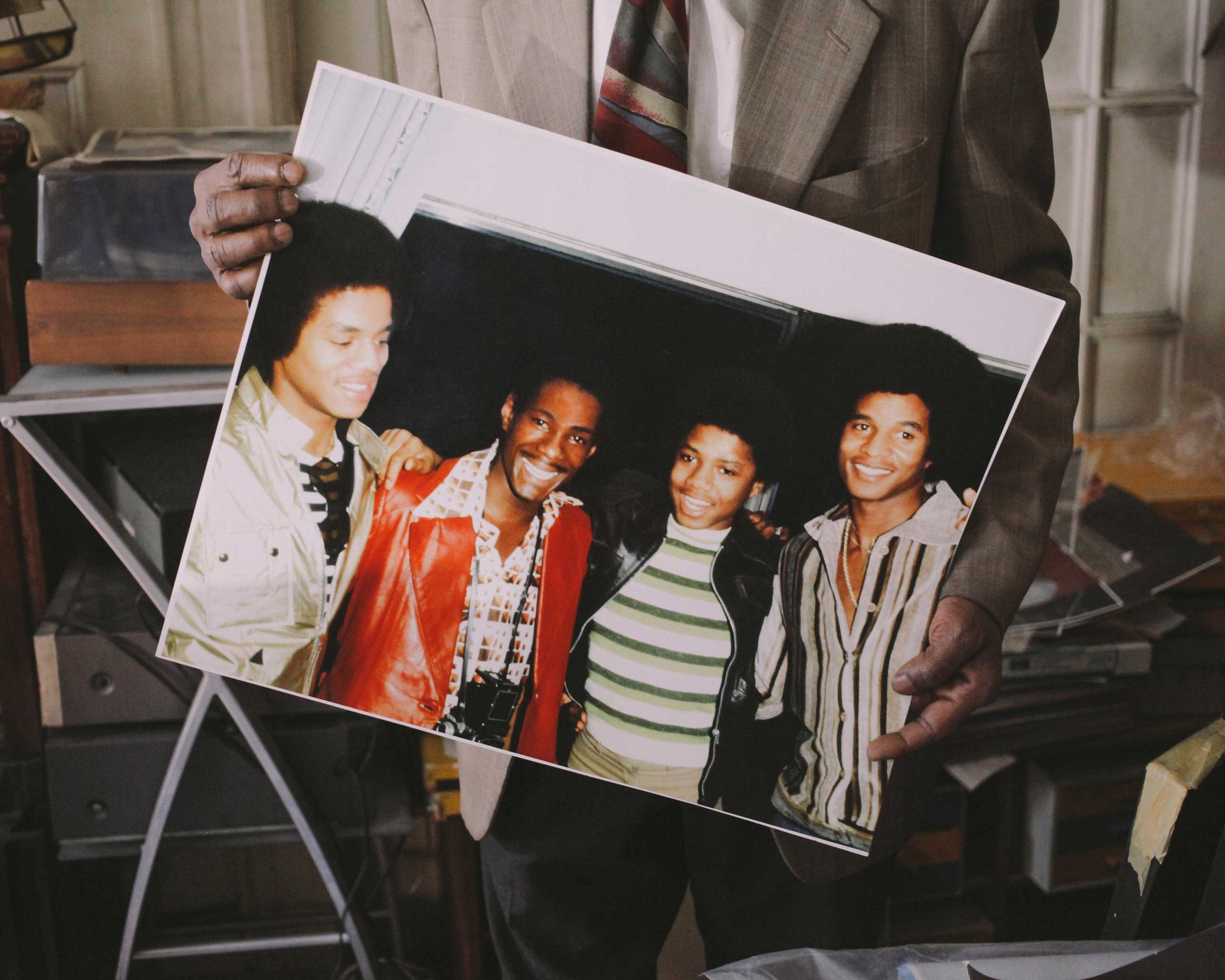 Alix Dejean holds a photo of himself with the Jacksons. (Nathan Bajar)