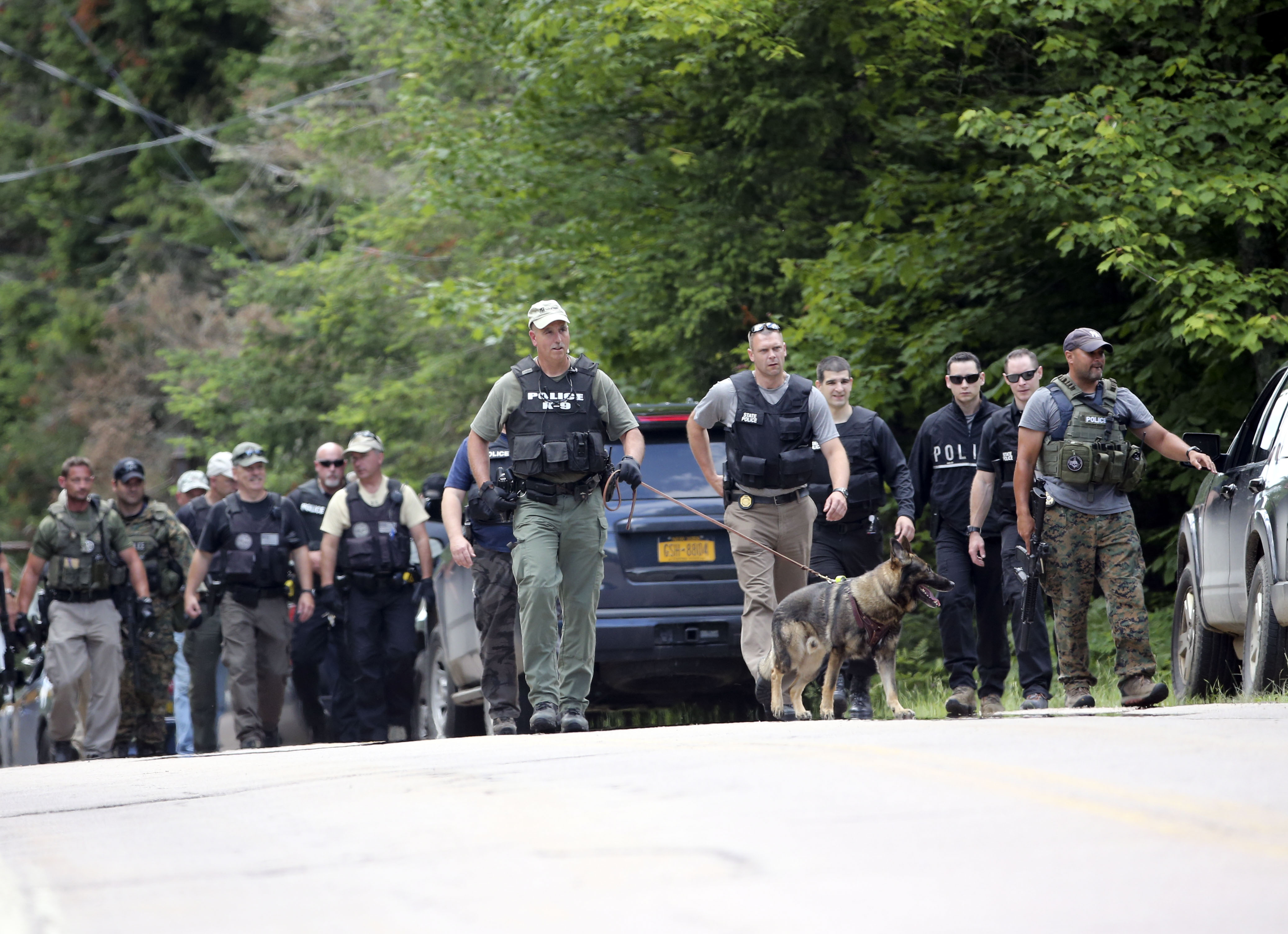 Law enforcement officers walk along a road as the search continues for two escaped prisoners from the Clinton Correctional Facility in Dannemora, on Monday, June 22, 2015 (Mike Groll—AP)
