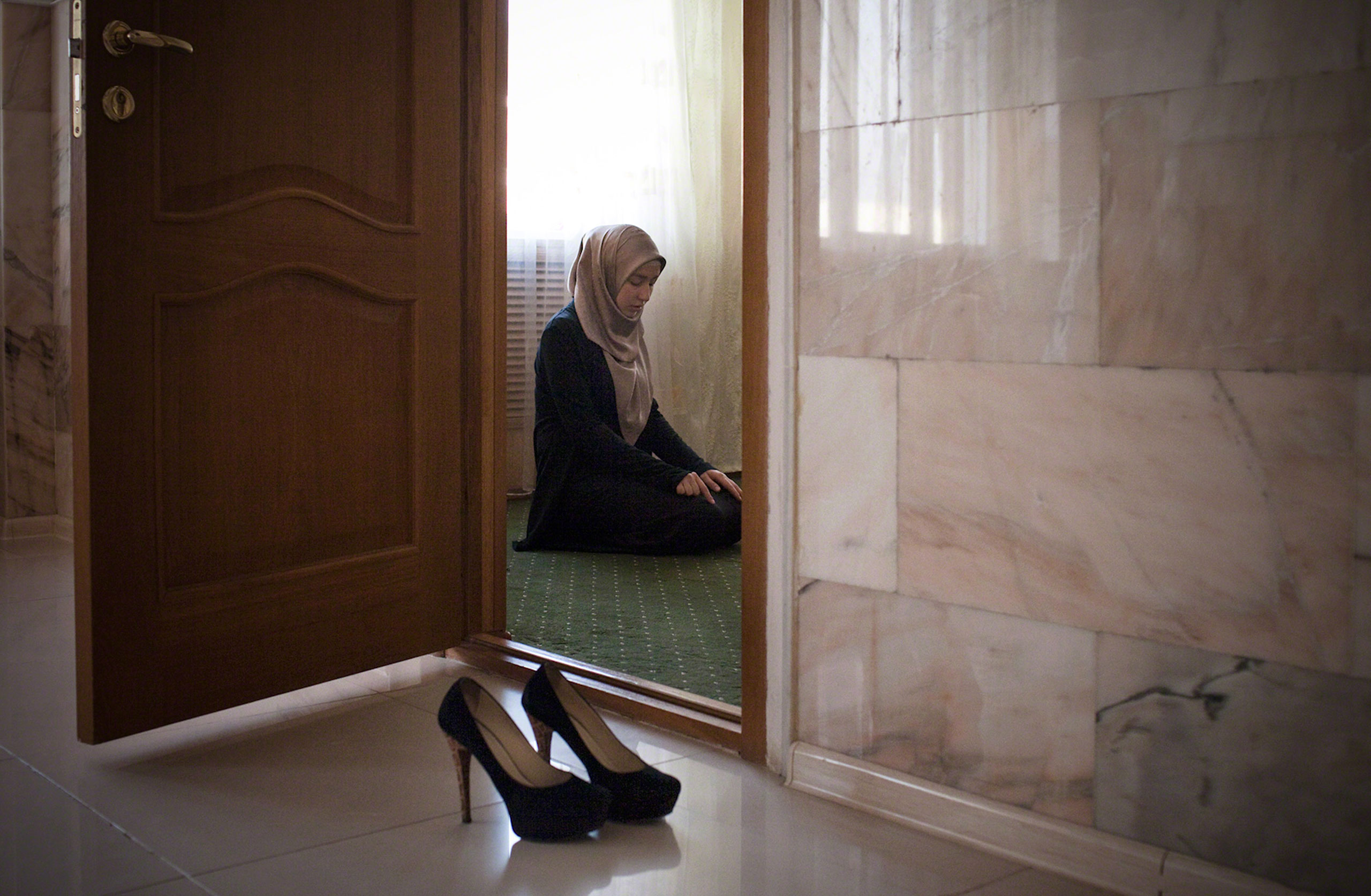 Amina Mutieva, 21, a student at the Islamic University in Grozny, prays in a prayer room for women, 2012.