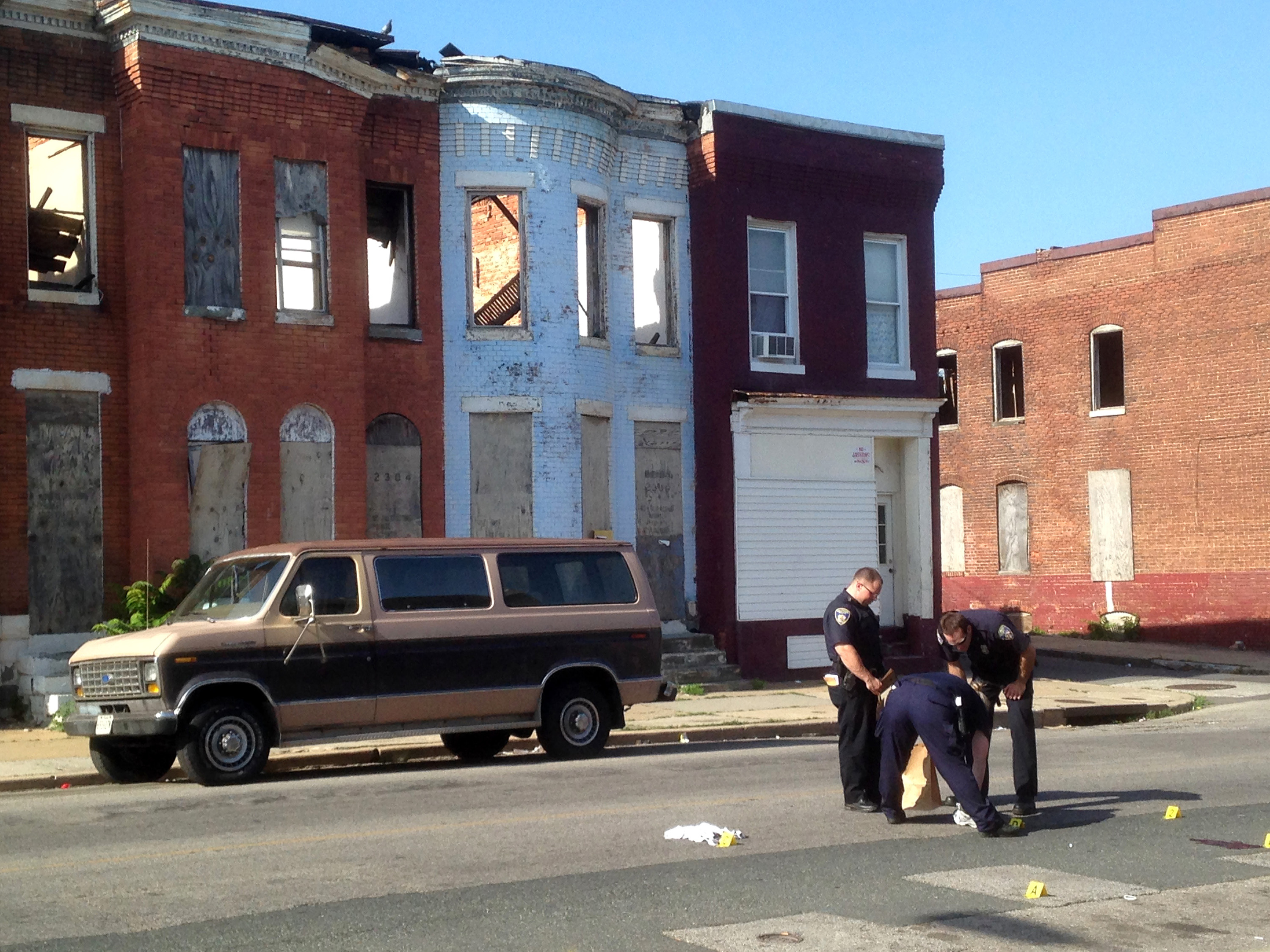 Police pick up a pair of tennis shoes after a double shooting in the 2300 block of E. Preston Street in Broadway East on May 24, 2015 in Baltimore, Md. (Colin Campbell—Baltimore Sun/Getty Images)