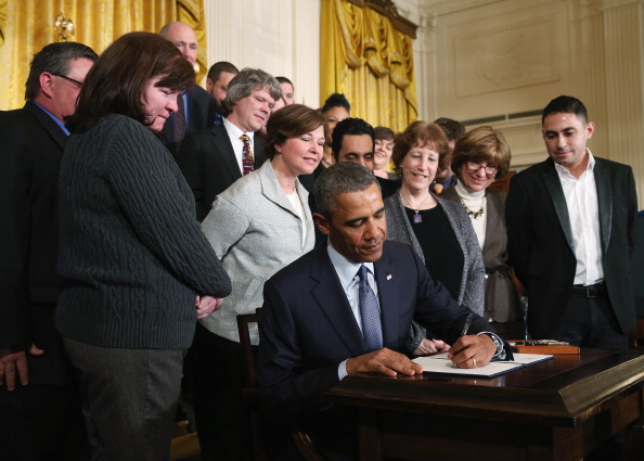 U.S. President Barack Obama signs a presidential memorandum for overtime protections for workers during an event in the East Room at the White House, on March 13, 2014 in Washington, D.C.