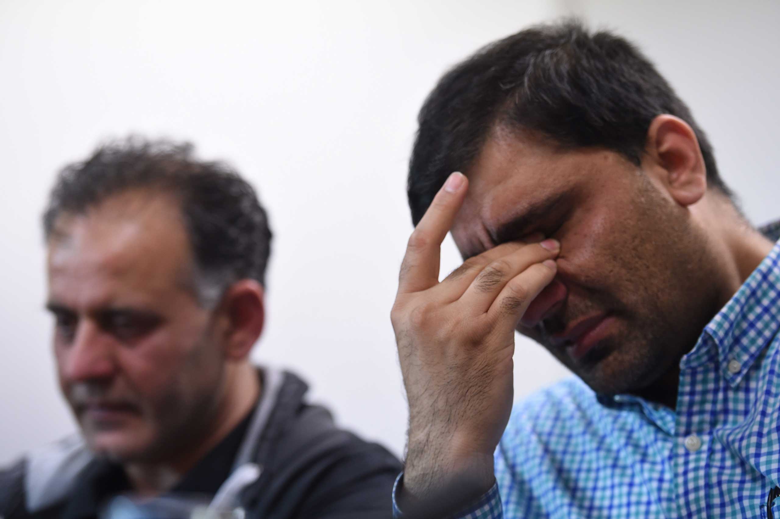 Akhtar Iqbal, husband of Sugra Dawood, left, and Mohammad Shoaib, husband of Khadija Dawood, react during a news conference to appeal for their return, in Bradford, northern England on June 16, 2015. (Paul Ellis—AFP/Getty Images)