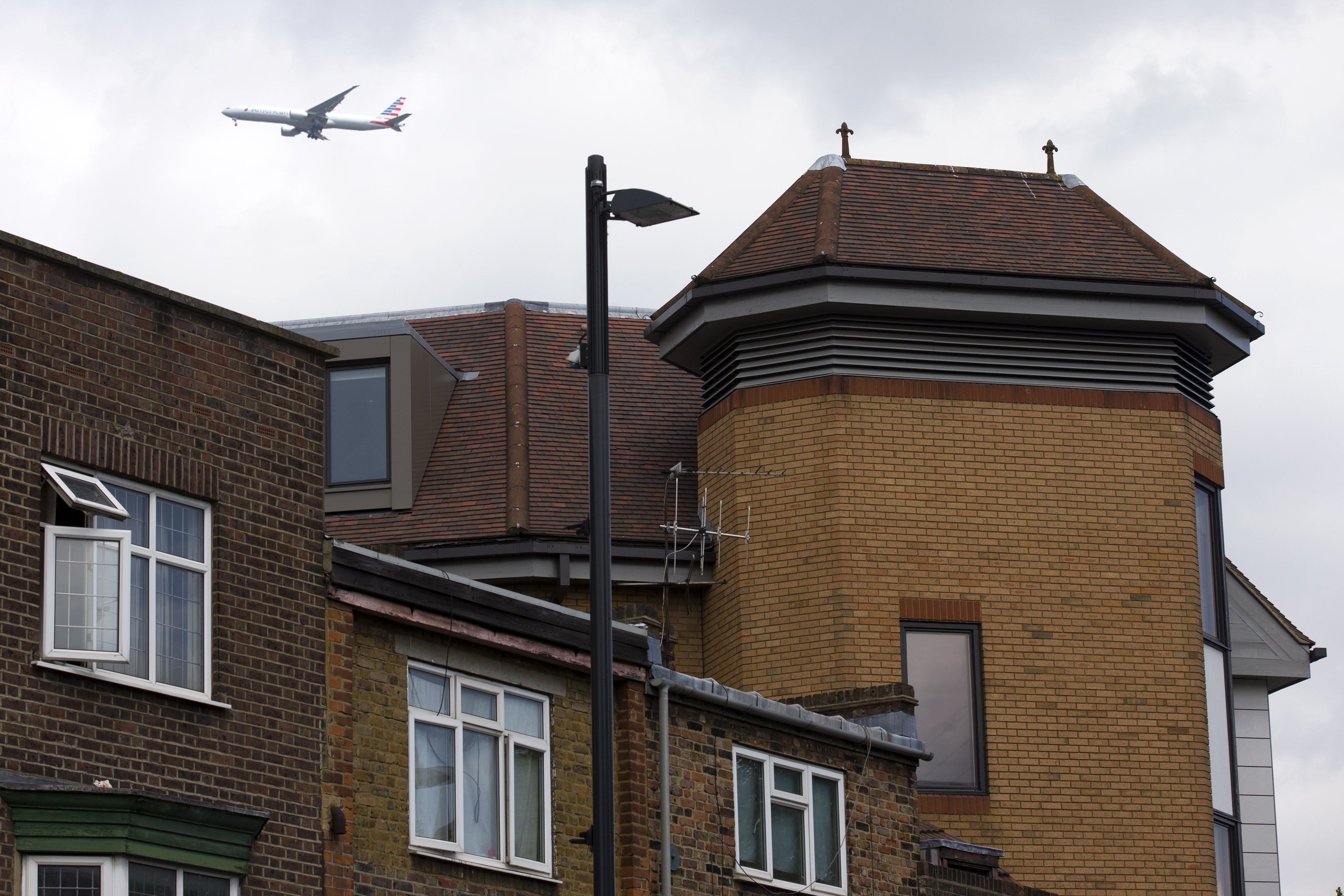 A airplane flies on June 19, 2015 past the offices of notonthehighstreet.com, an online retailer in Richmond, London where the body of a dead man was found on the roof on June 18.