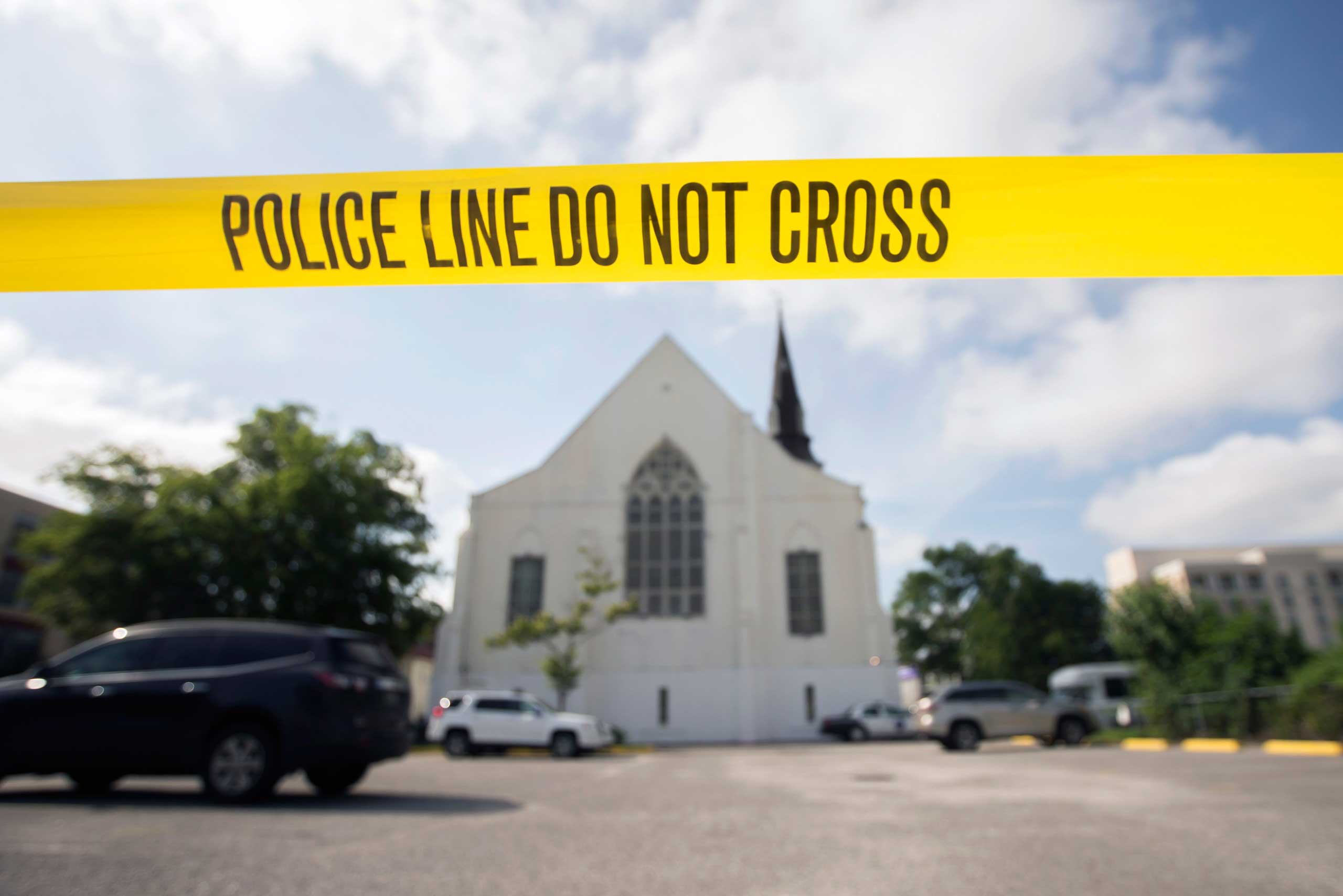 Police tape surrounds the parking lot behind the AME Emanuel Church as FBI forensic experts work the crime scene where nine were killed in Charleston, S.C., on June 19, 2015. (Stephen B. Morton—AP)