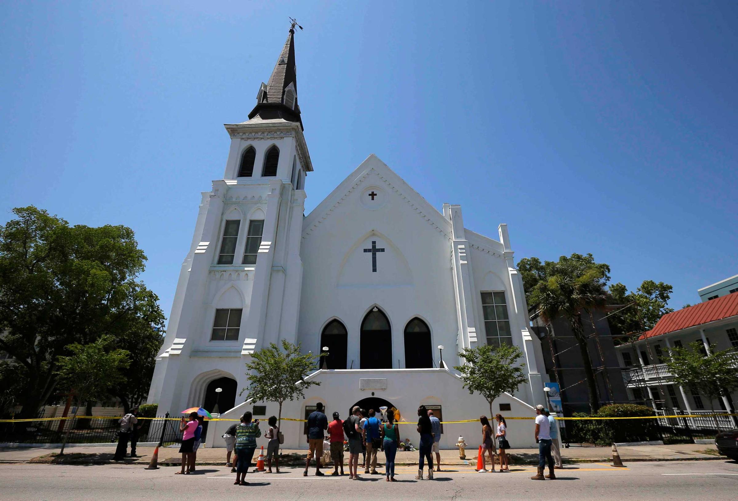 People gather outside Emanuel African Methodist Episcopal Church after the street was re-opened a day after a mass shooting left nine dead during a bible study at the church in Charleston