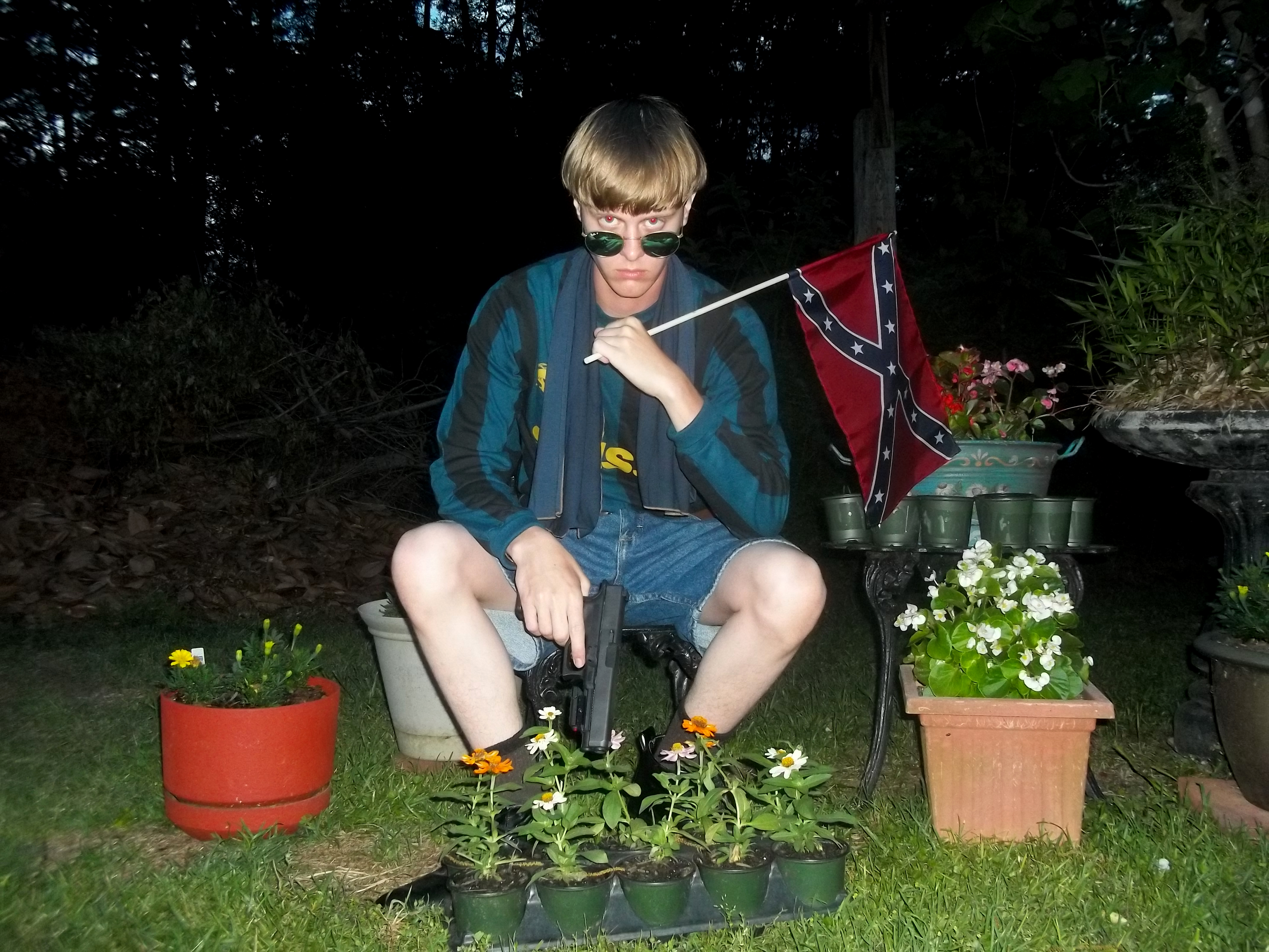 Dylann Roof poses for a photo while holding a Confederate flag (AP)