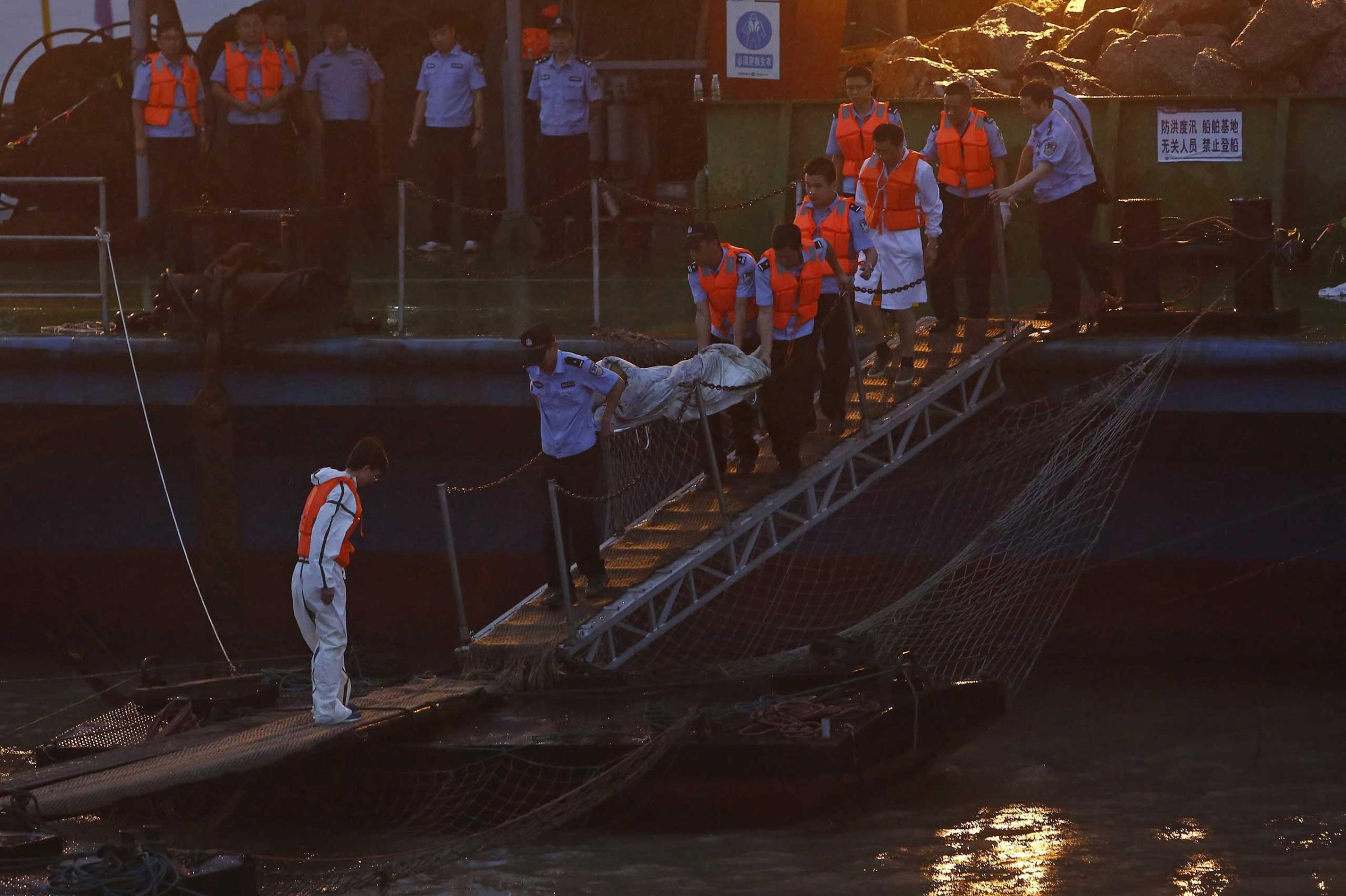 Rescue workers carry a body from the sunken ship in the Jianli section of Yangtze River, Hubei province, China on June 2, 2015.