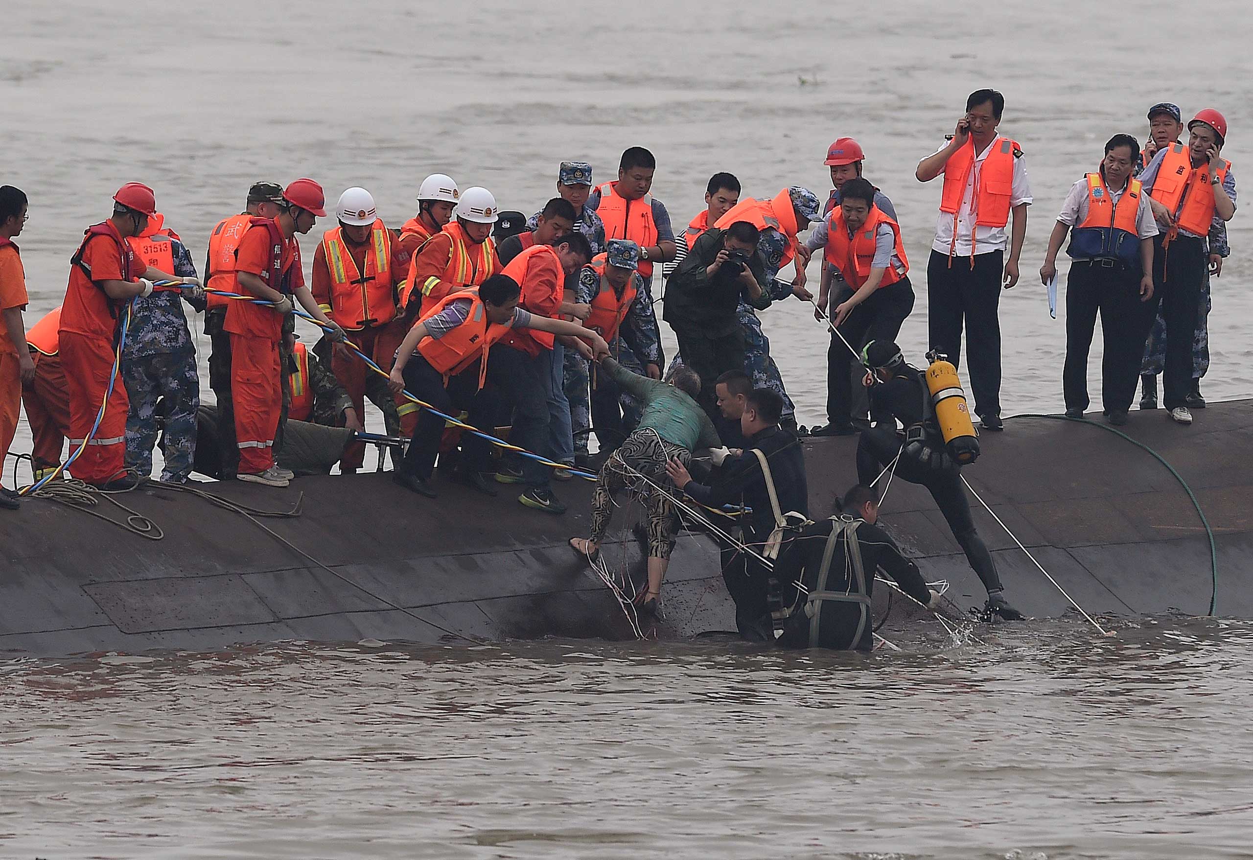 Rescuers save a survivor, center, from the overturned passenger ship in the Jianli section of the Yangtze River in central China's Hubei Province on June 2, 2015.