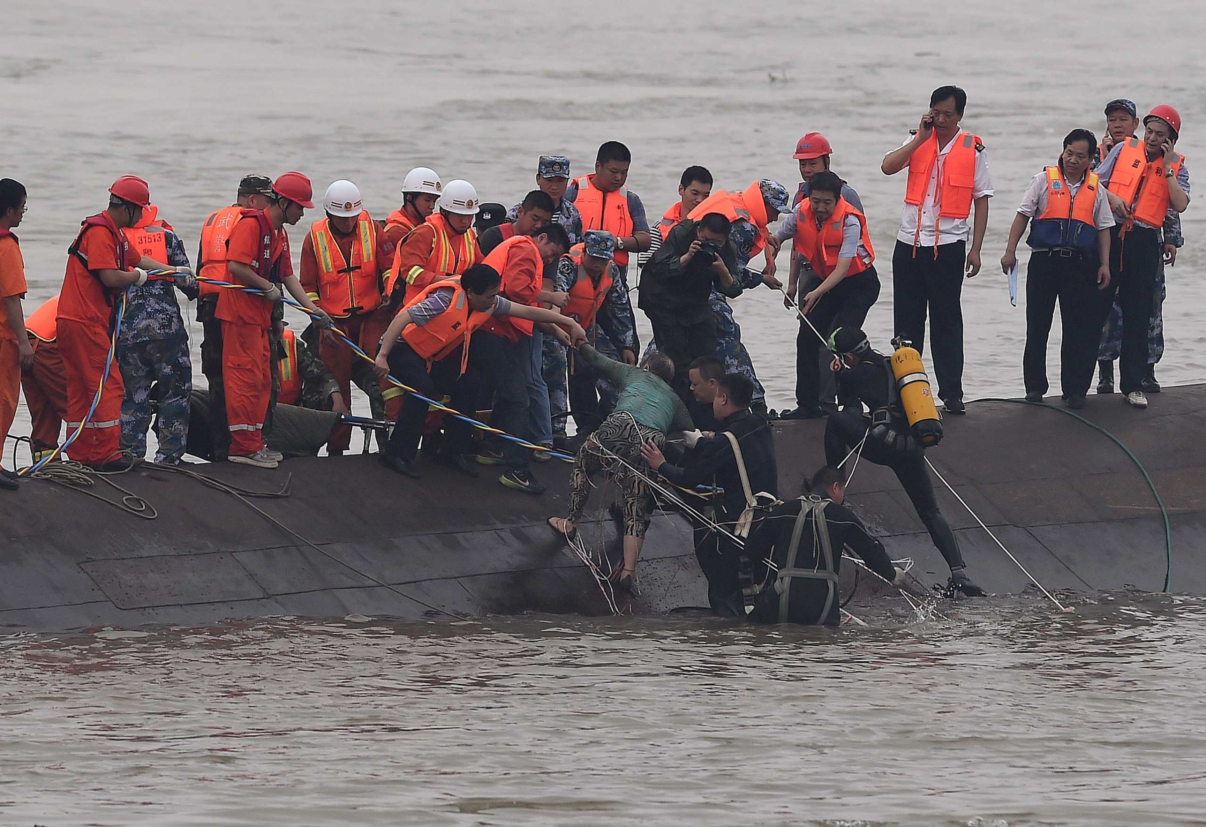 Rescuers save a survivor, center, from the overturned passenger ship in the Jianli section of the Yangtze River in central China's Hubei Province on June 2, 2015.