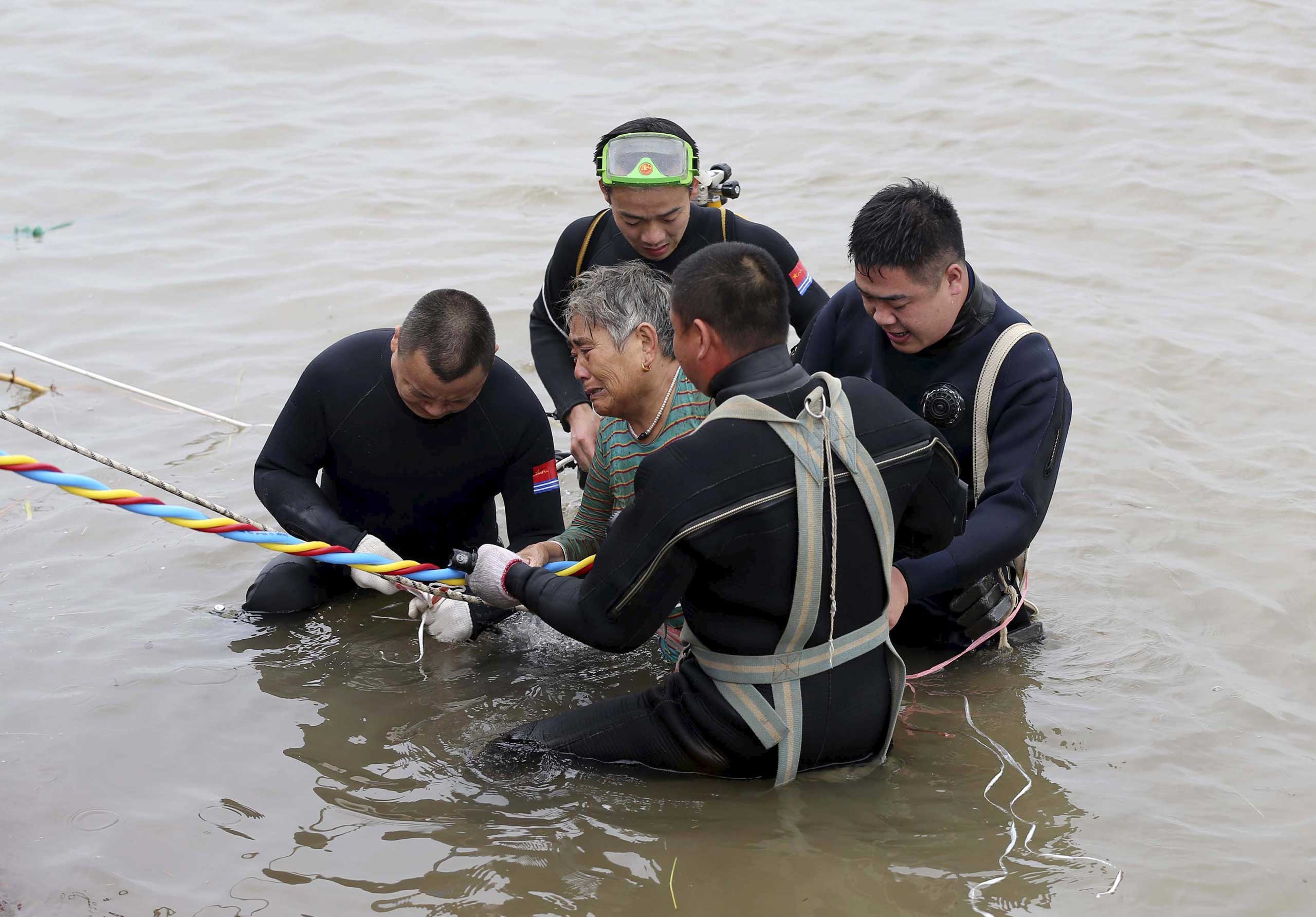 A woman is helped after being pulled out by divers from a sunken ship in Jianli, Hubei province, China on June 2, 2015.