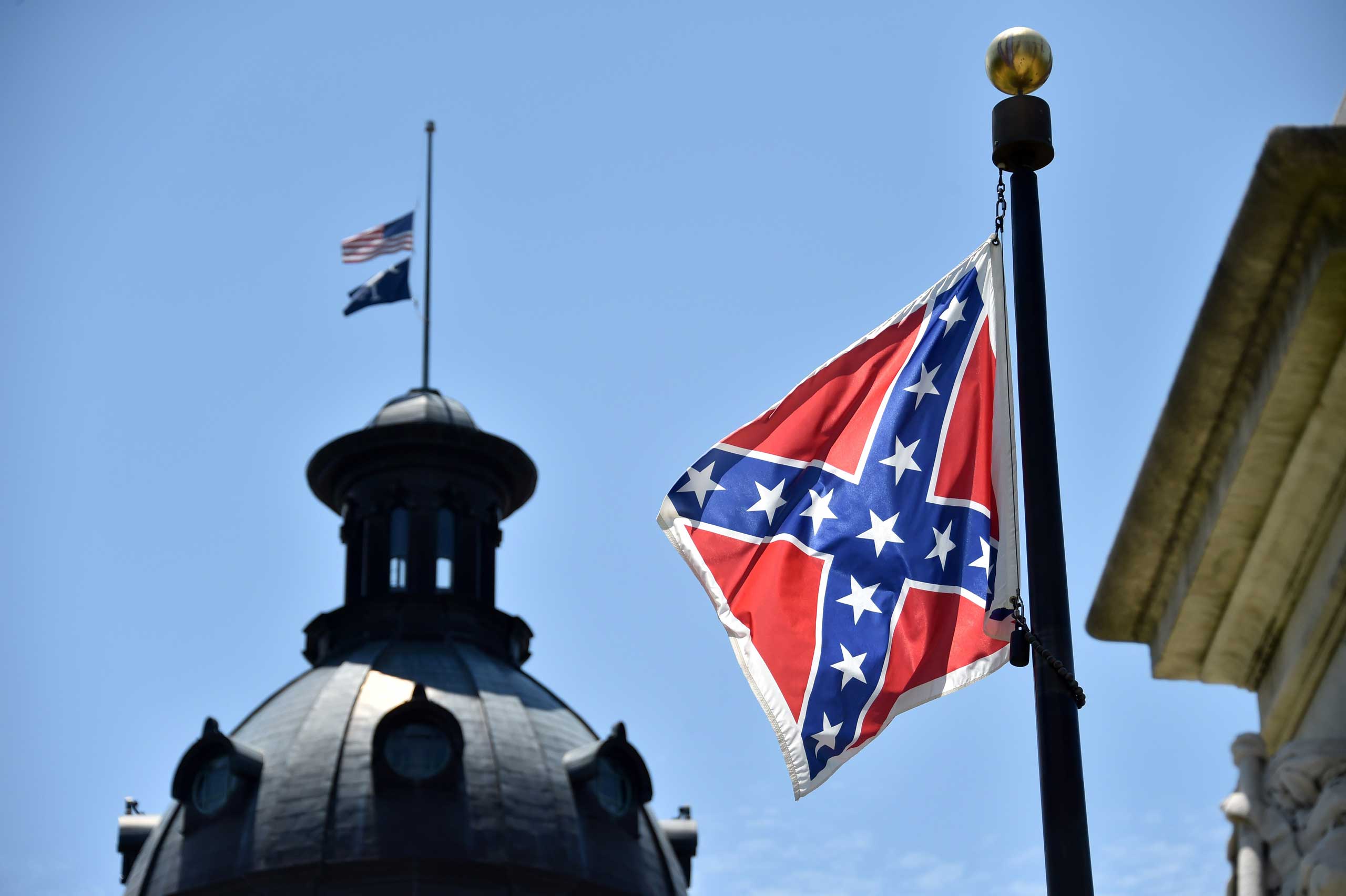 The South Carolina and American flags flying at half-staff behind the Confederate flag erected in front of the State Congress building in Columbia, South Carolina on June 19, 2015. (Mladen Antonov — AFP/Getty Images)