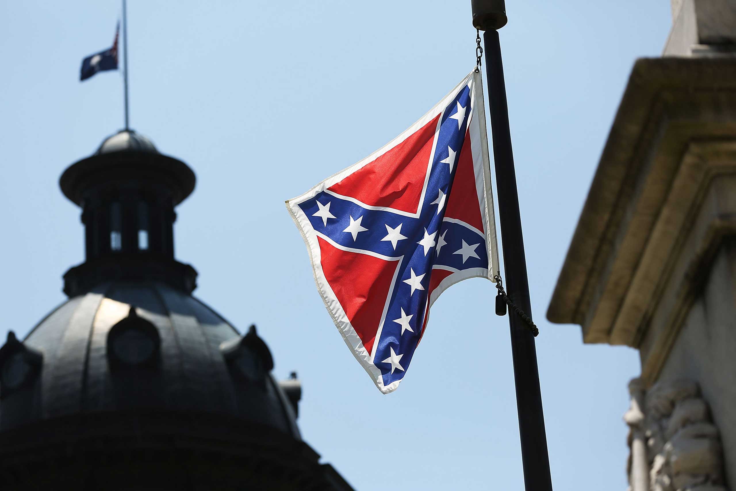 The Confederate flag is seen flying on the Capitol grounds a day after South Carolina Gov. (Joe Raedle — Getty Images)