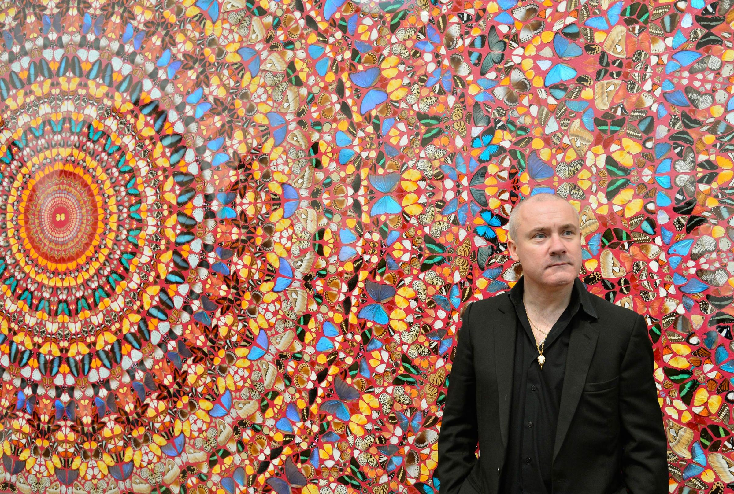 British artist Damien Hirst poses next to his painting "I Am Become Death, Shatterer of Worlds", at the Tate Modern gallery in London