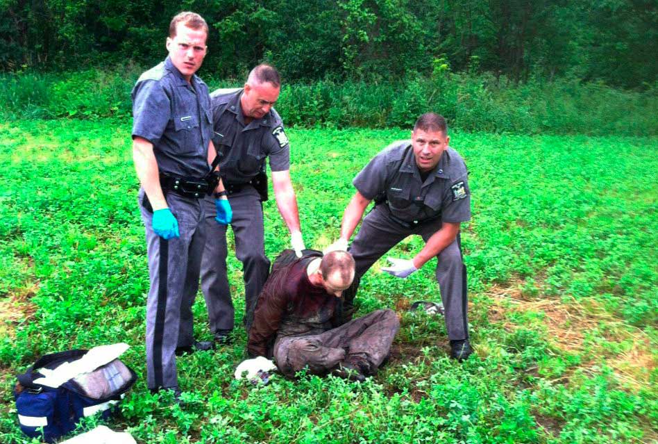 Police stand over David Sweat after he was shot and captured near the Canadian border in Constable, N.Y. on June 28, 2015. (AP)