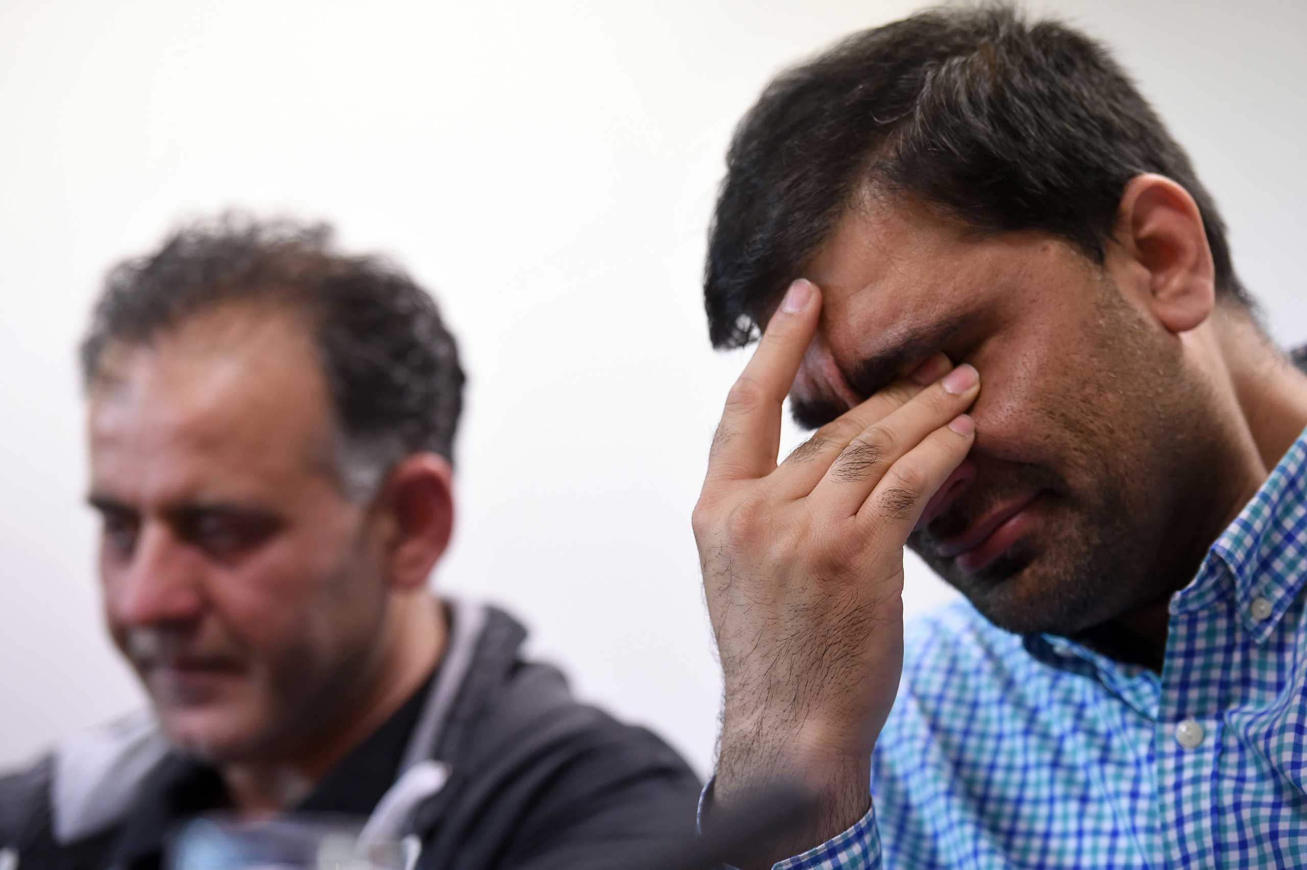 Akhtar Iqbal, husband of Sugra Dawood (L), and Mohammed Shoaib, husband of Khadija Dawood, react during a news conference to appeal for the return of their wives and children, in Bradford, northern England, on June 16, 2015. (Paul Ellis—AFP/Getty Images)