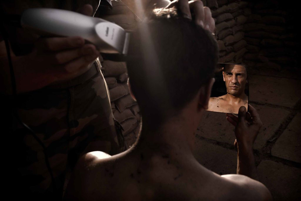 A French Foreign Legion soldier is getting his head shaved.