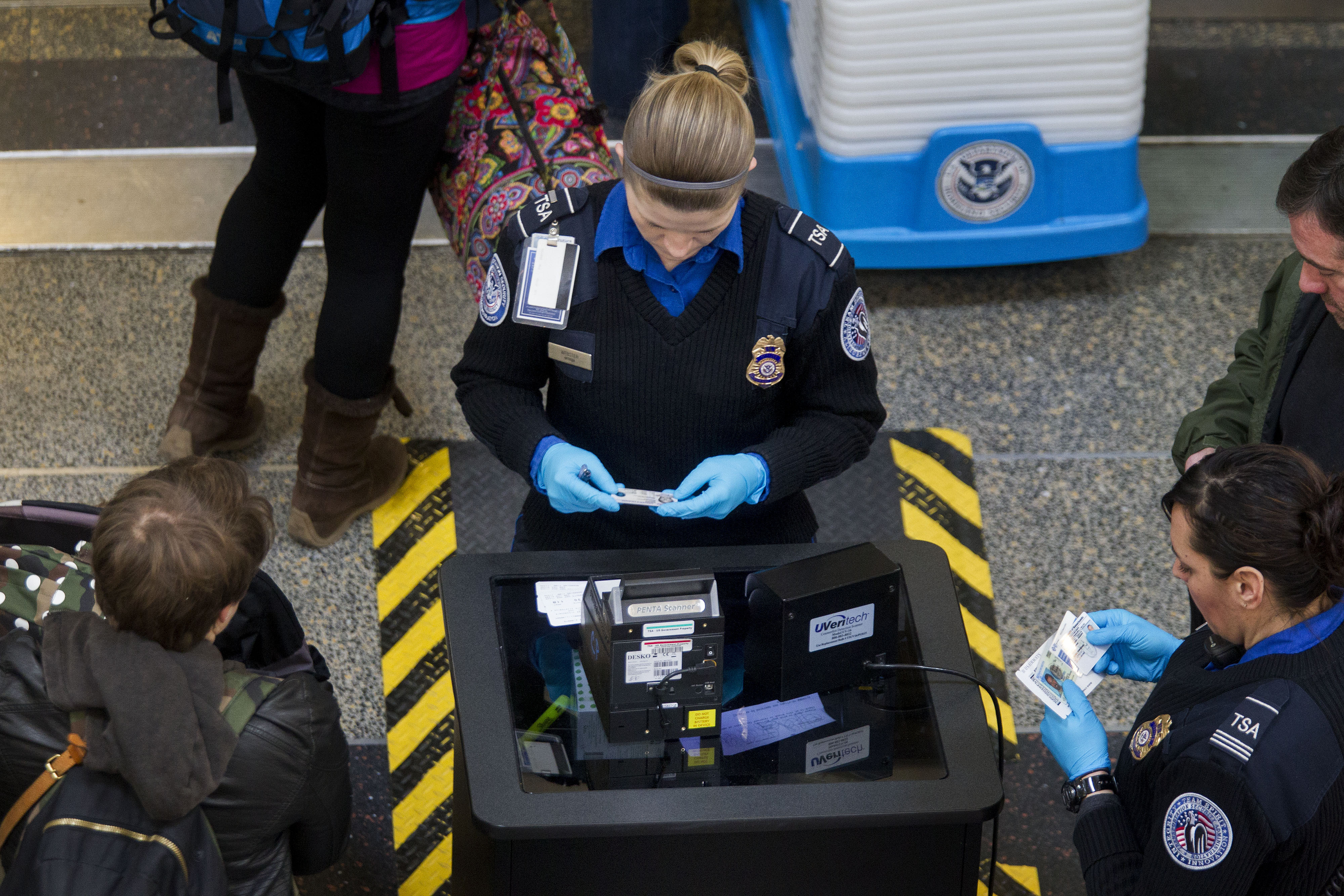 Transportation Security Administration (TSA) officers check passenger's identification at a security checkpoint at Ronald Reagan National Airport (DCA) in Washington, D.C., U.S., on Wednesday, Feb. 25, 2015. Financing for the U.S. Department of Homeland Security (DHS) is set to lapse after Friday and the agency would face a partial shutdown unless Congress provides new money. More than 200,000 government employees deemed essential at DHS, including TSA officers, would still have to report to their posts, even though their pay would stop unless Congress finds a solution. Photographer: Andrew Harrer/Bloomberg via Getty Images (Bloomberg&mdash;Bloomberg via Getty Images)