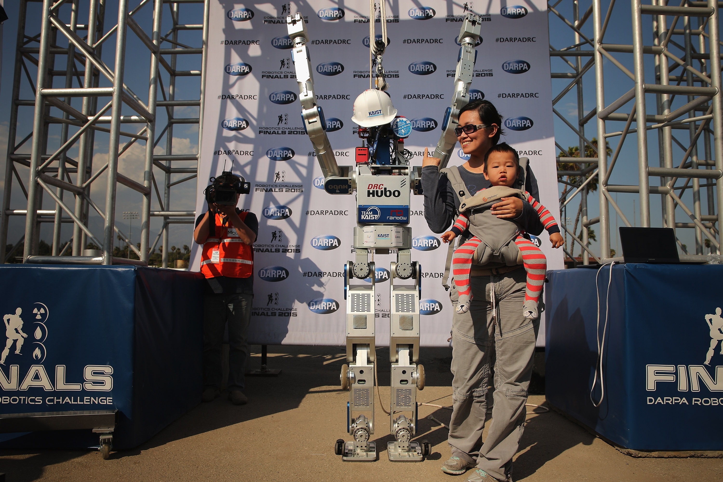 Fans pose for photographs with Team Kaist's DRC-HUBO robot after its successful run during the Defense Advanced Research Projects Agency (DARPA) Robotics Challenge at the Fairplex June 6, 2015 in Pomona, California. (Chip Somodevilla—Getty Images)