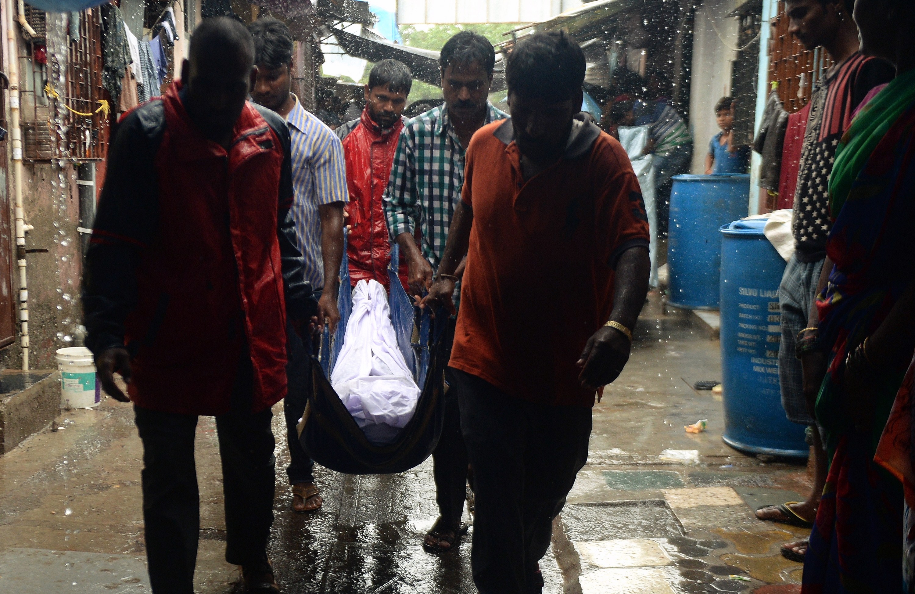 Family members carry the body of a victim of toxic homemade liquor consumption in Mumbai on June 20, 2015 (Punit Paranjpe—AFP/Getty Images)