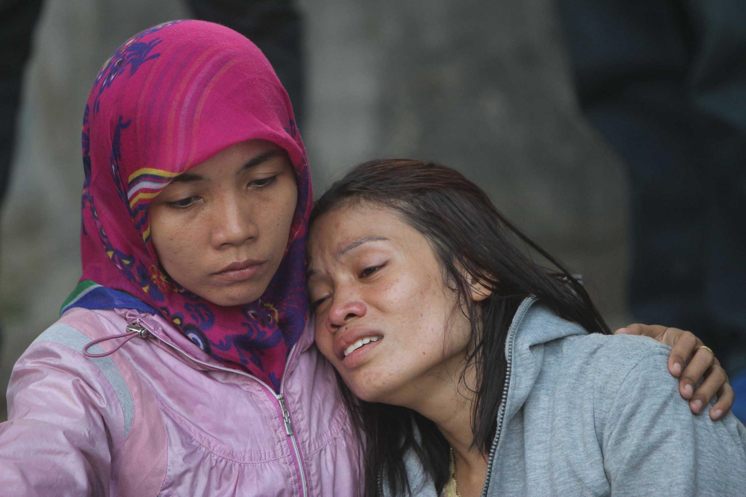 Relatives of victims grieve outside the Adam Malik hospital following the Indonesian Air Force C-130 Hercules aircraft crash in Medan, Indonesia on June 30, 2015.