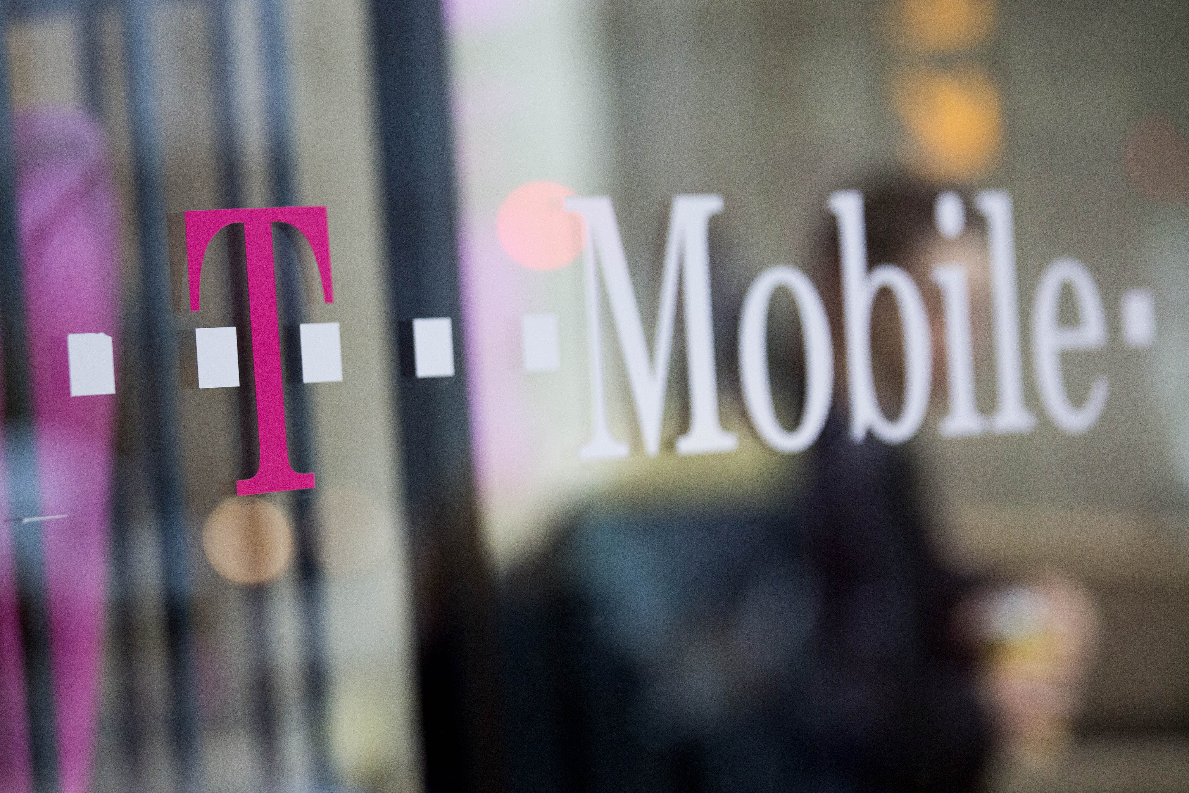 T-Mobile US Inc. signage is displayed in the window of a retail store in Washington, D.C., on Oct. 23, 2014. (Bloomberg via Getty Images)