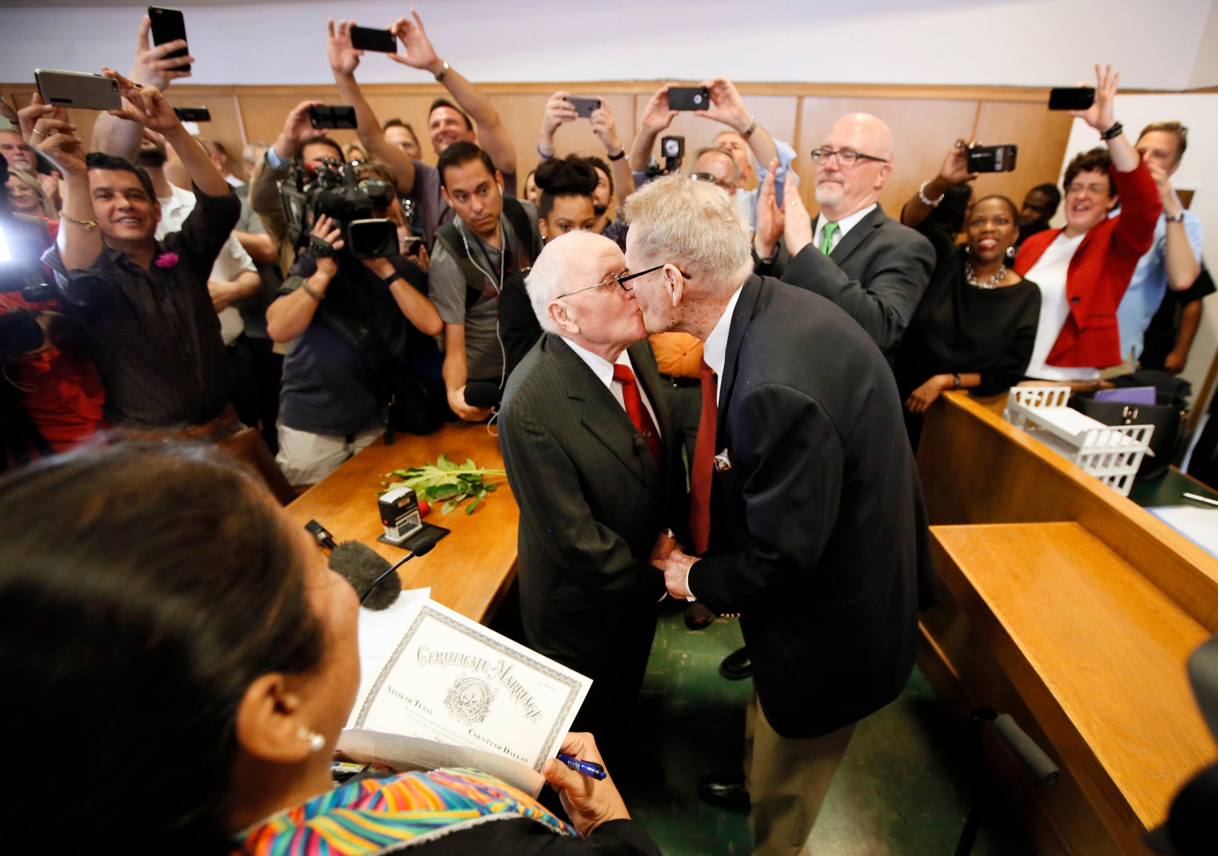 Judge Dennise Garcia, left front, watches as George Harris, center left, 82, and Jack Evans, center right, 85, kiss after being married by Judge Garcia in Dallas on June 26, 2015.