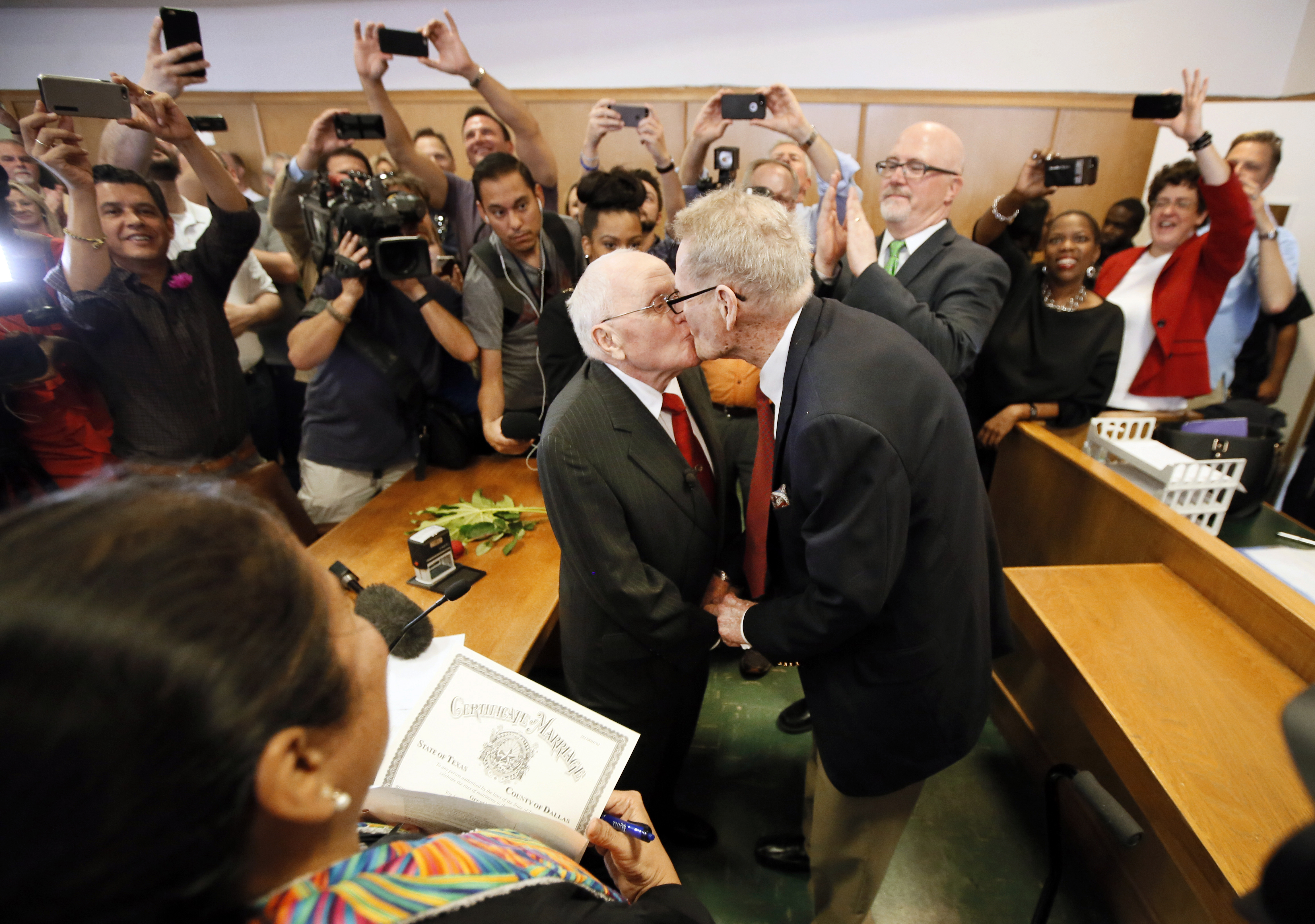 Judge Dennise Garcia, left front, watches as George Harris, center left, 82, and Jack Evans, center right, 85, kiss after being married by Judge Garcia in Dallas on June 26, 2015. (Tony Gutierrez—AP)