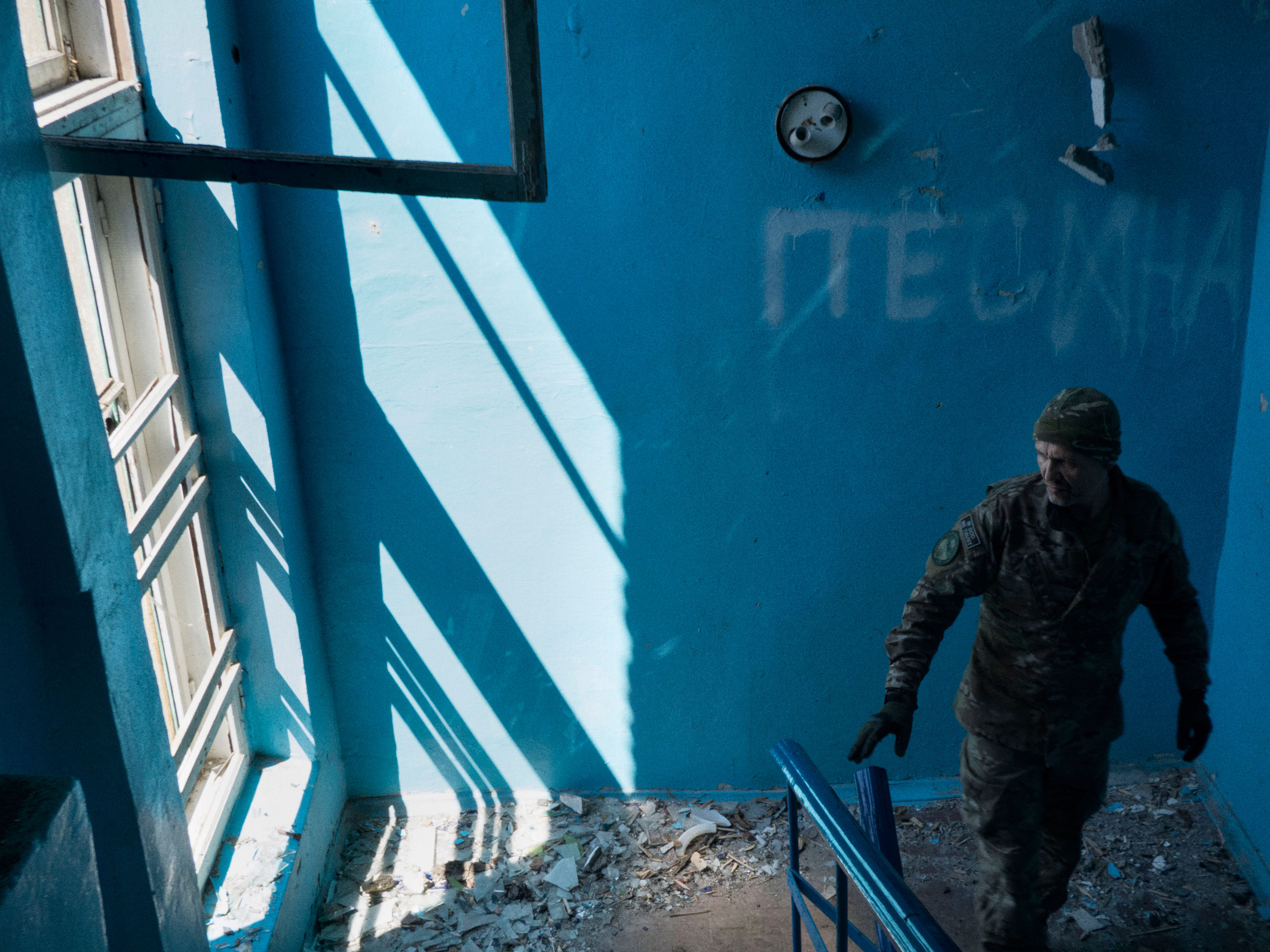 A Ukrainian soldier walks carefully inside a building that is targeted by pro-Russian forces on the frontline near Mariupol. Shyrokyne, Ukraine. June 3, 2015.