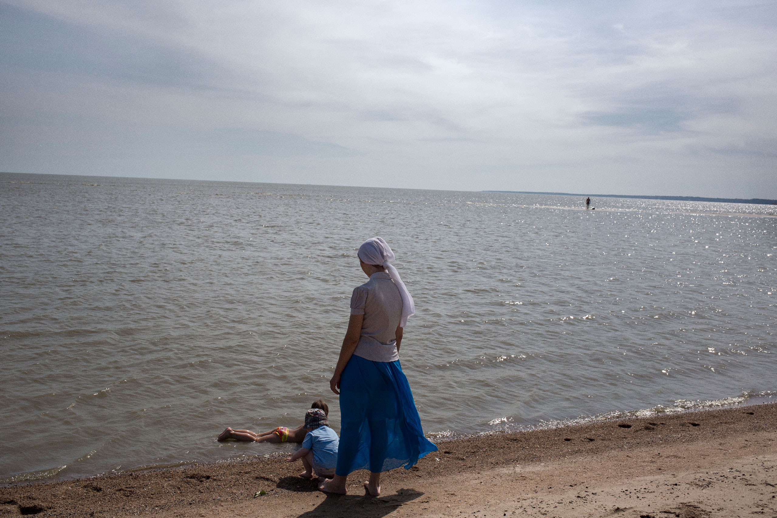 A woman and two children on what is normally the area’s most crowded beach. Mariupol, Ukraine. May 24, 2015.