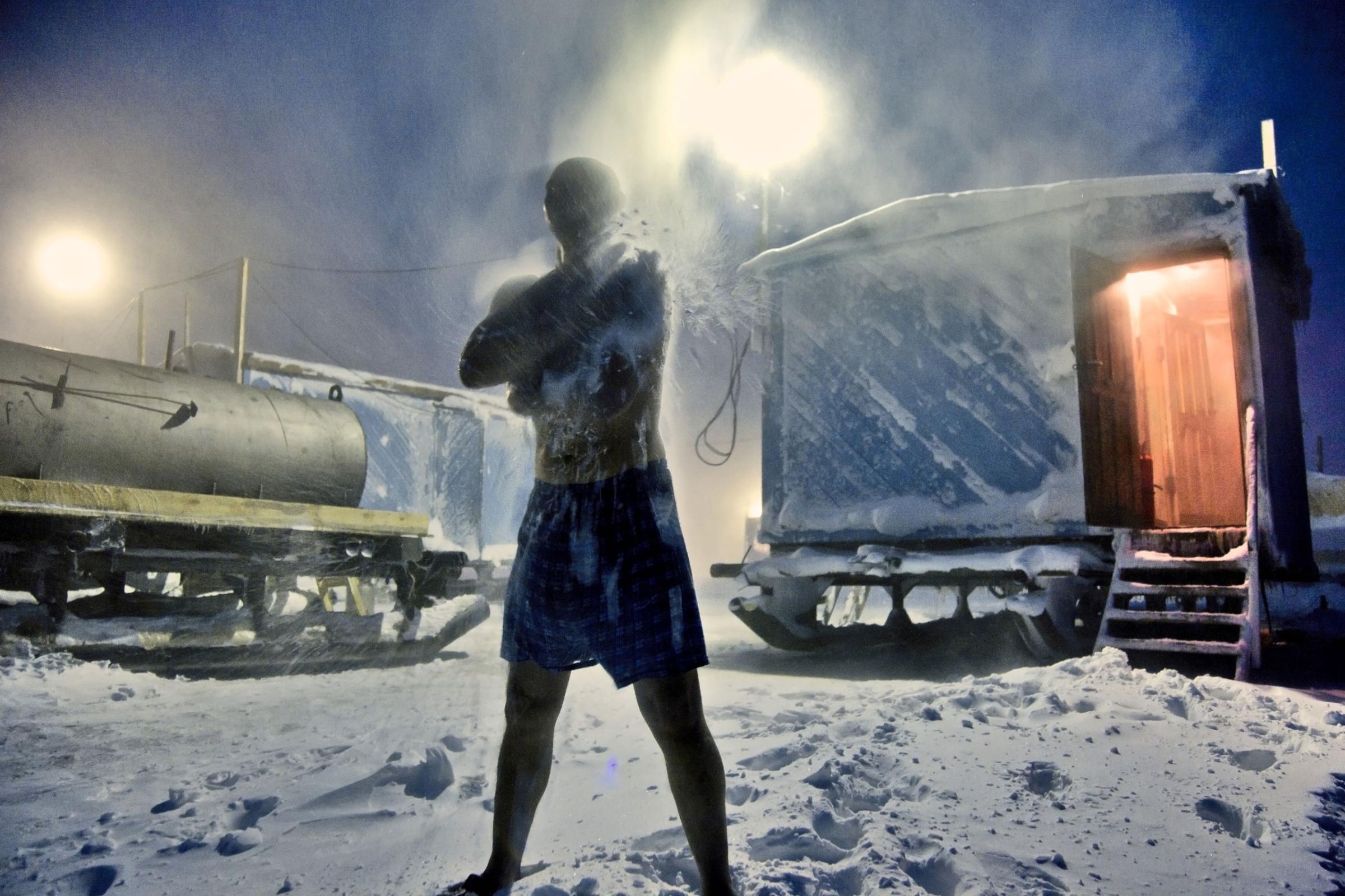 A worker rubs snow during sauna at Arctic gas prospecting site